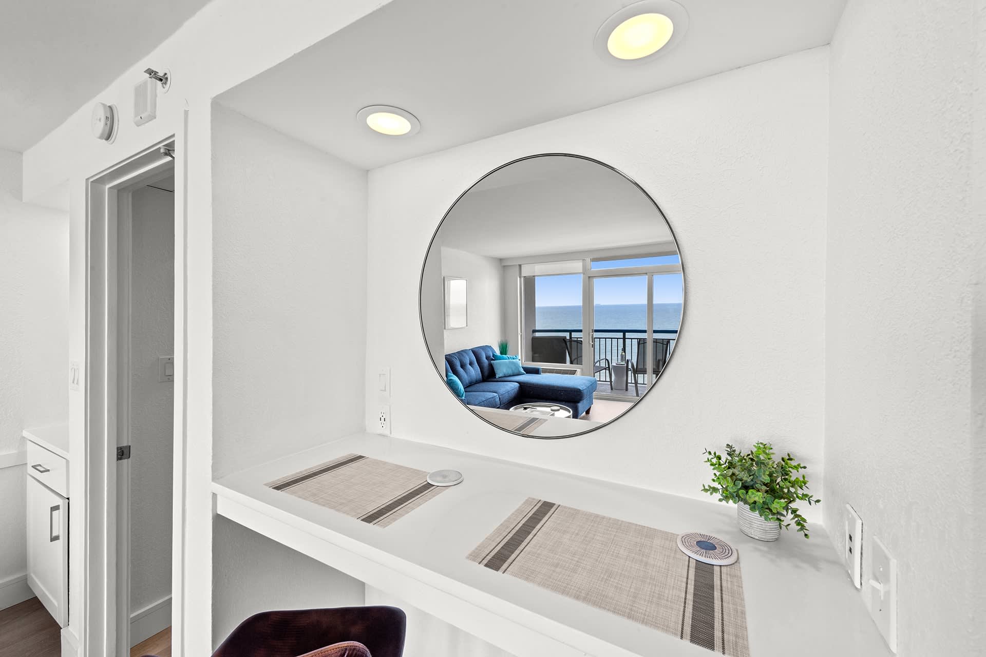 Enjoy ocean views from every angle—even while dining at this stylish breakfast nook. The round mirror perfectly frames the coastal scenery, creating a bright and inviting space to start your day by the sea.