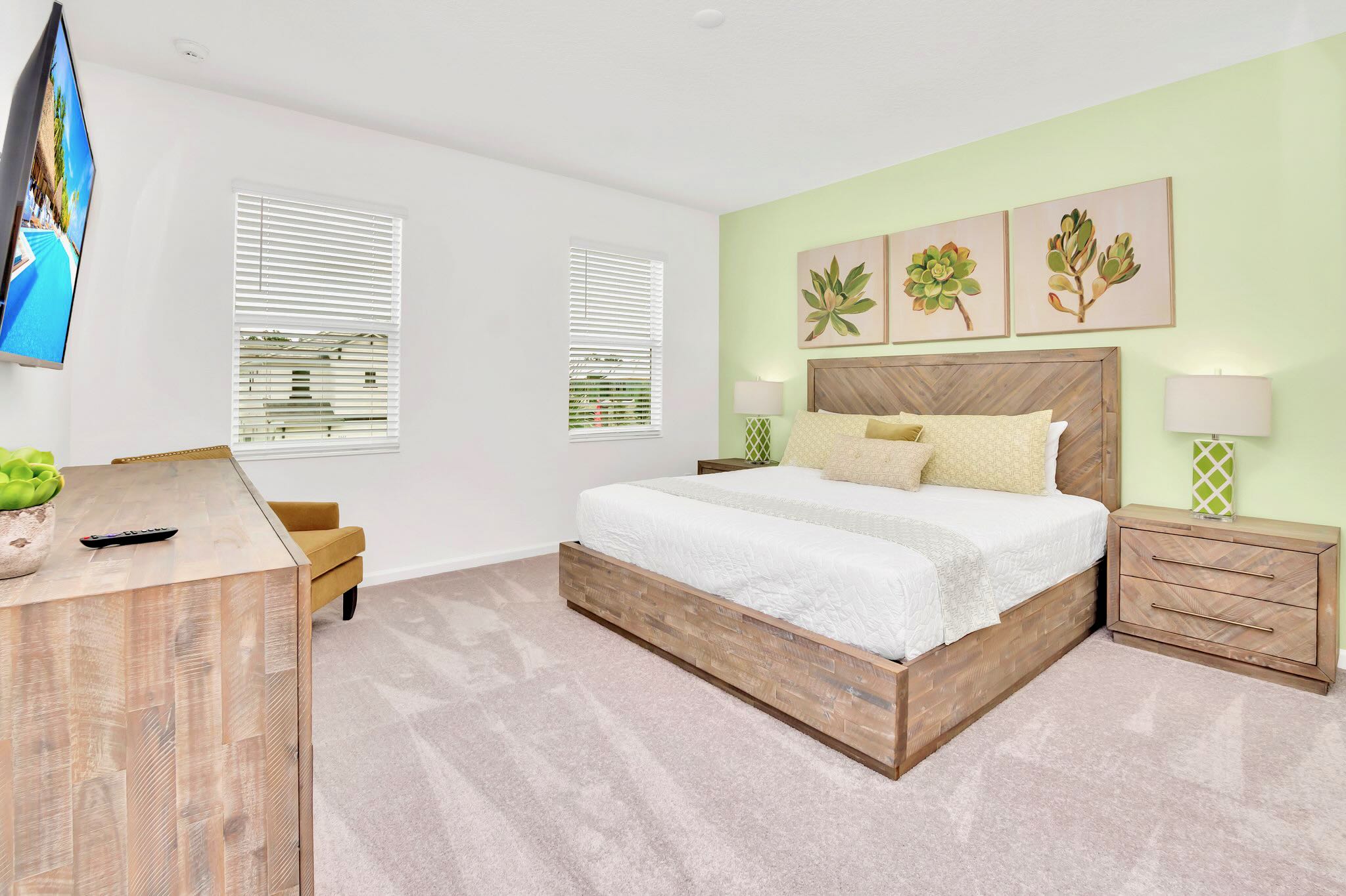 Modern King Bedroom Featuring Soft Green Accents, Sleek Design, And Ample Natural Light