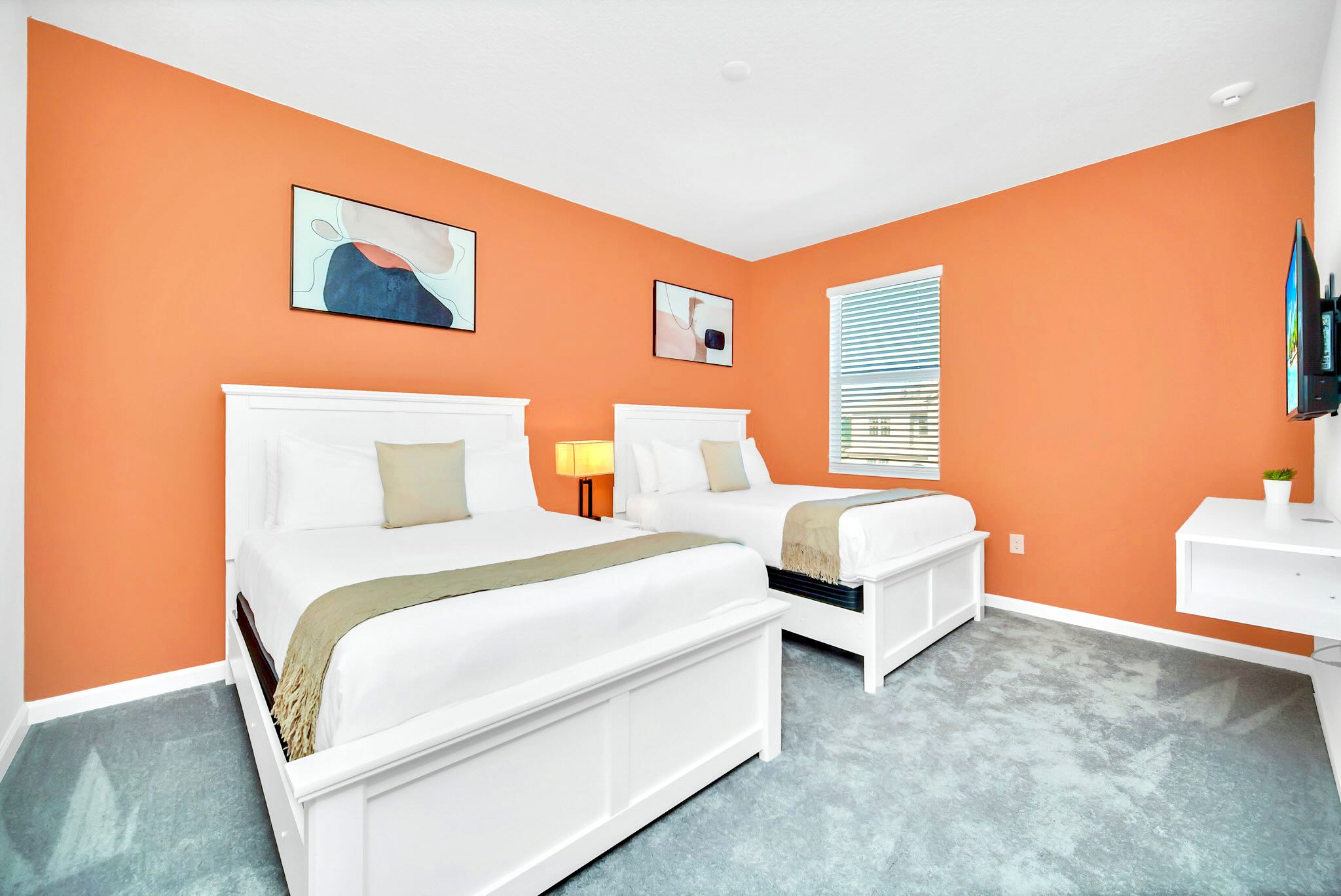 Twin Beds Offering A Relaxing Space With A Mounted Smart TV