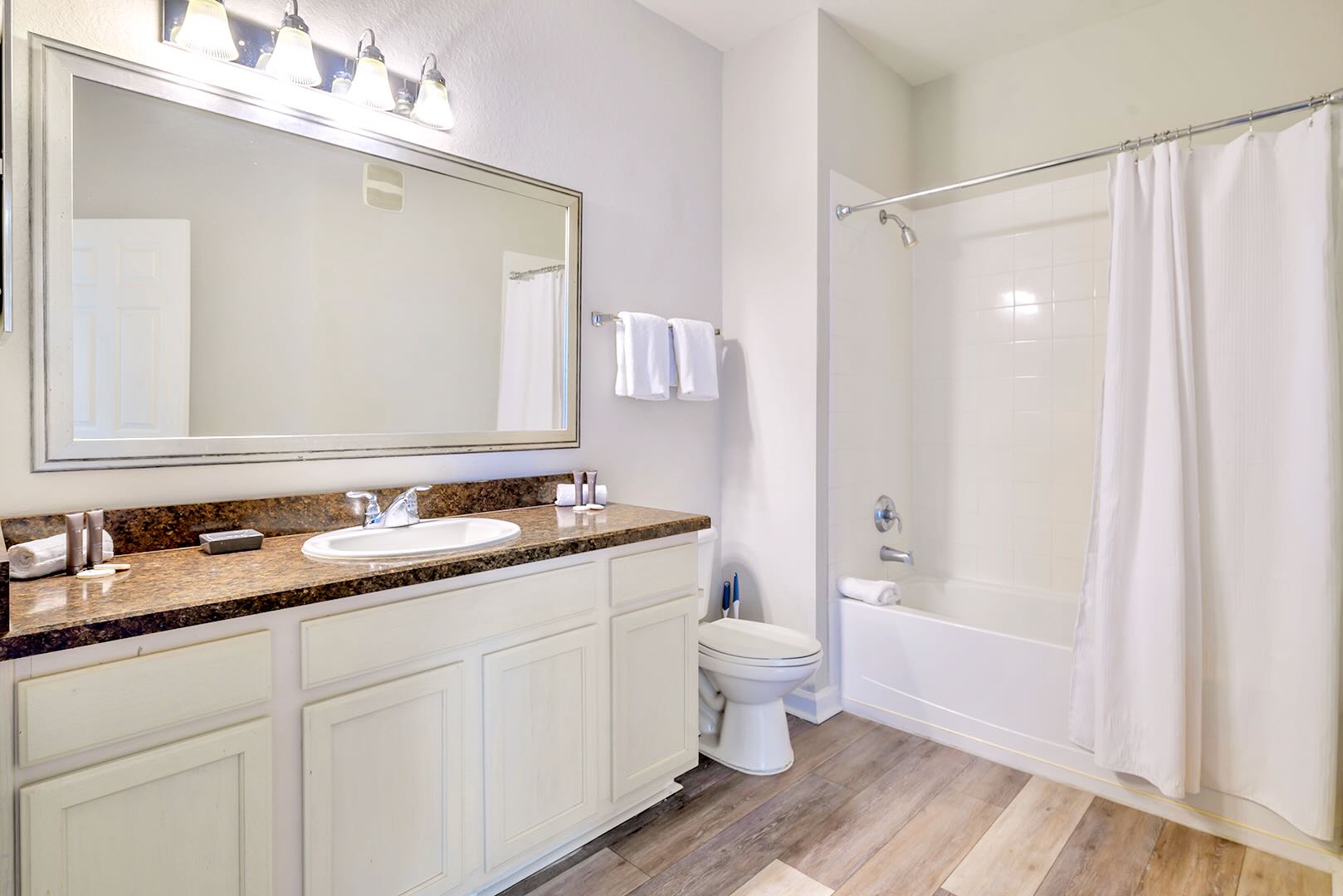 Bright Shared Bathroom Featuring Double Sinks And A Shower-Tub Combo