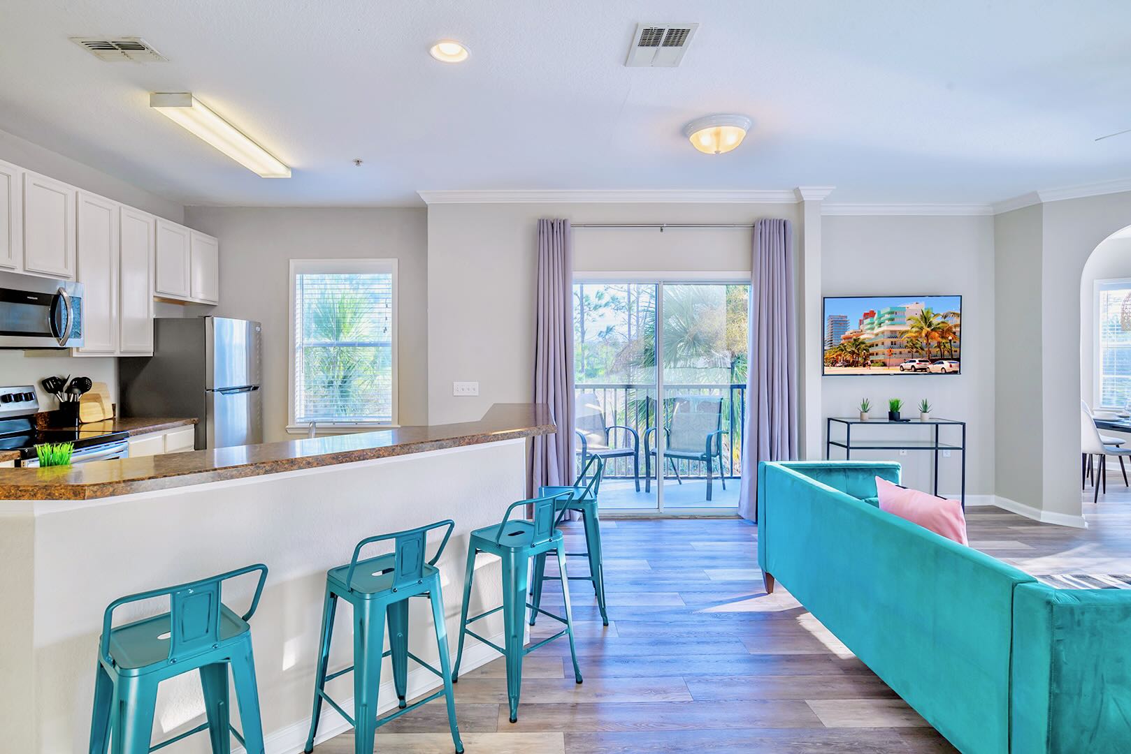 Open Kitchen And Living Room Layout With Modern Bar Seating And Vibrant Decor