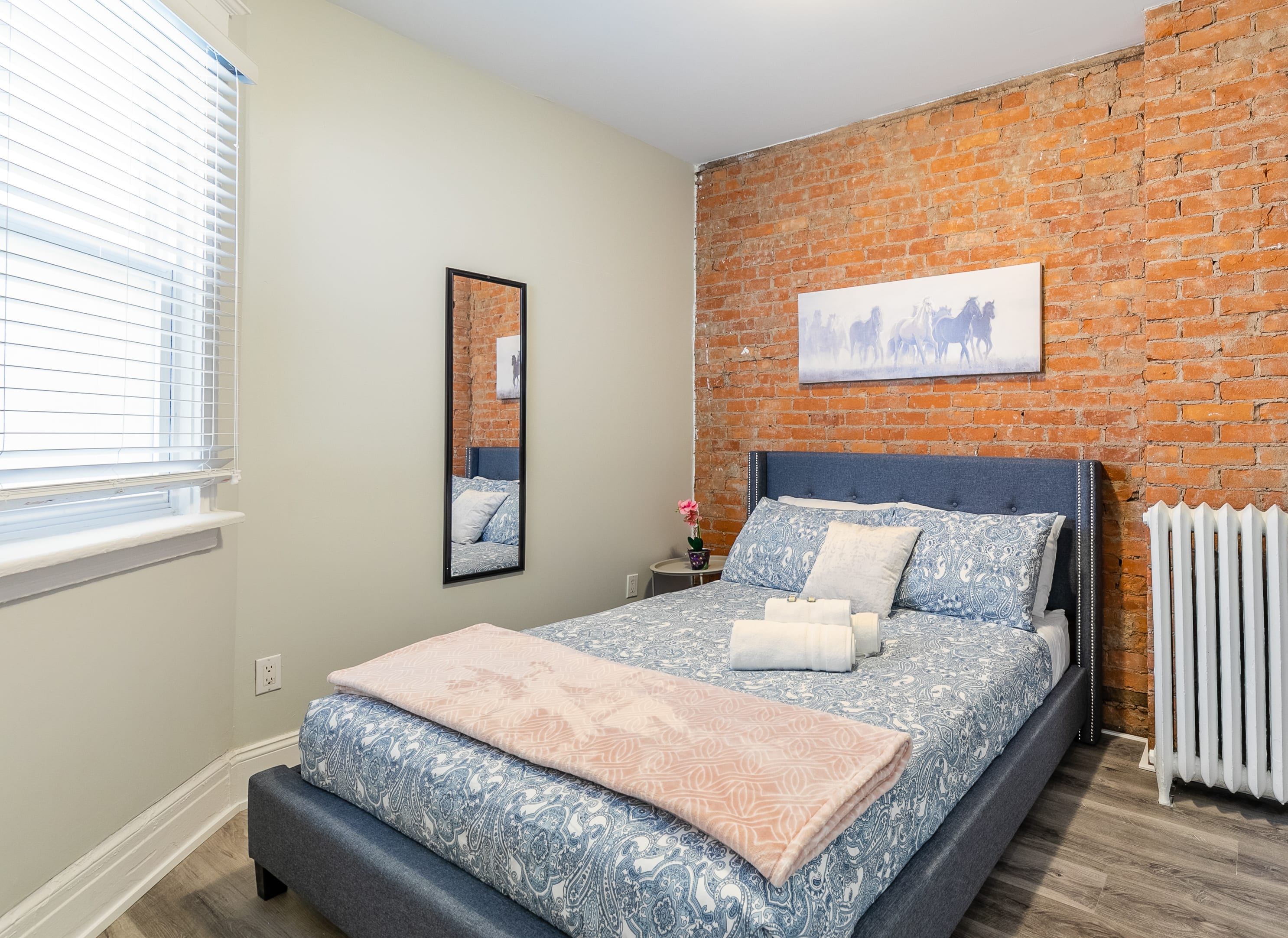 Queen Bed With Elegant Bedding And A Stunning Exposed Brick Wall Backdrop