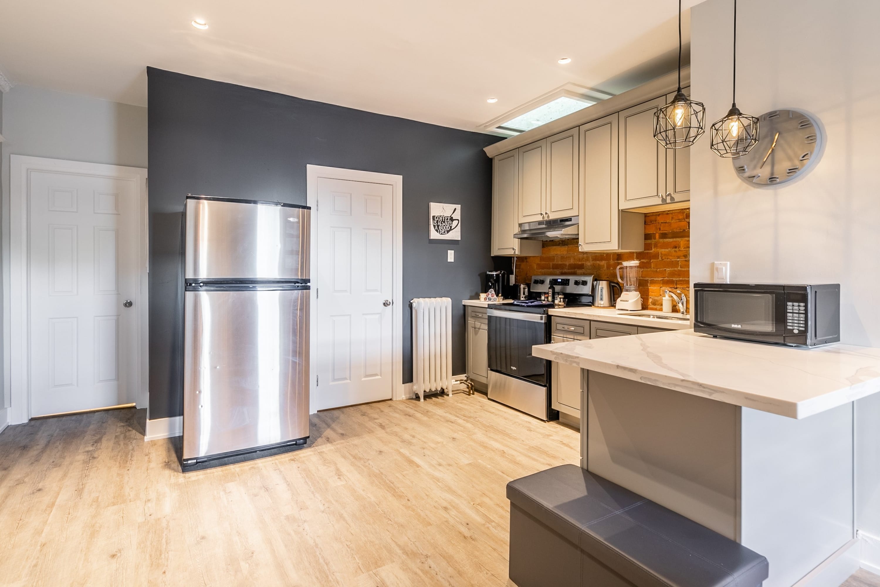 Fully Equipped Kitchen Featuring Sleek Countertops And Elegant Brick Accents