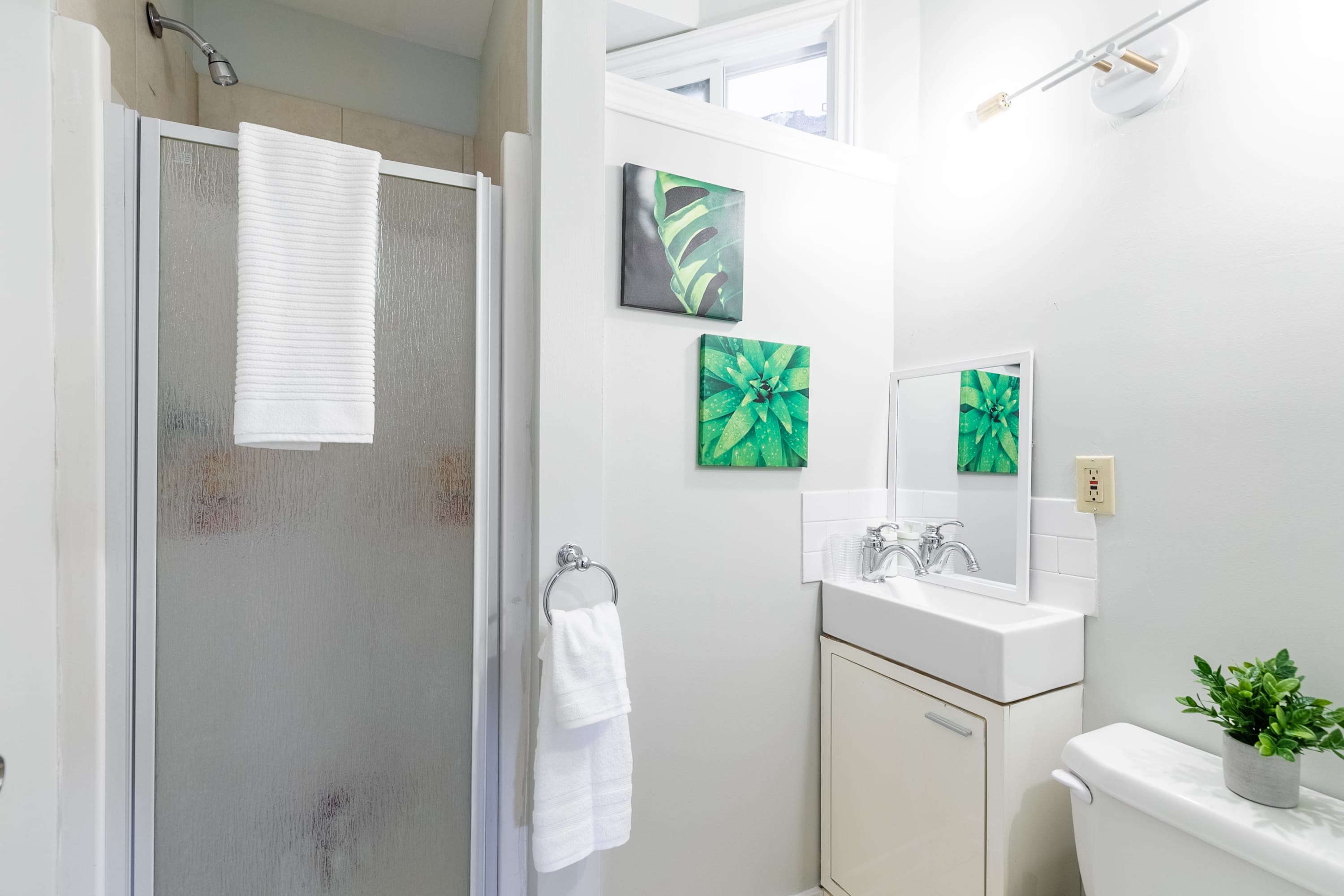 Bright Bathroom With A Walk-In Shower And Refreshing Green Decor Accents