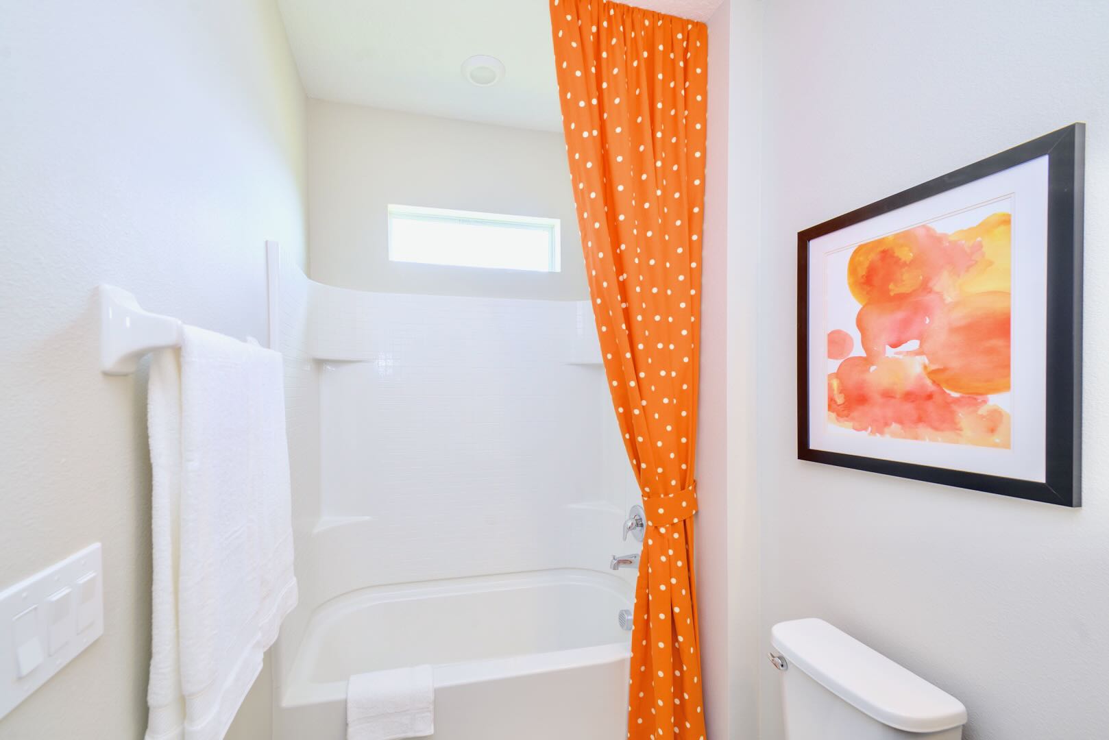 Spacious Bathroom Featuring Dual Vanity And Vibrant Artwork