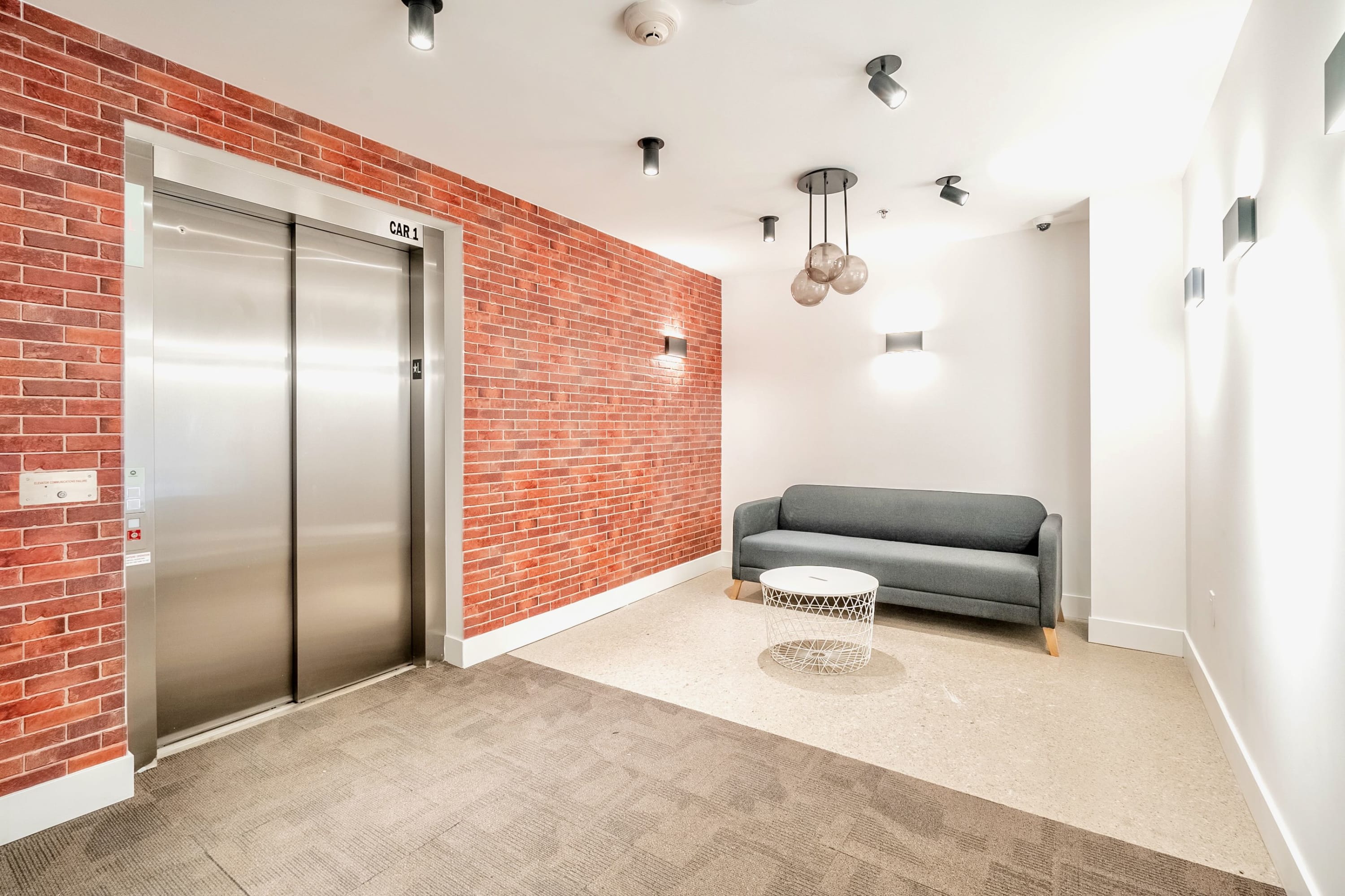 Elegant Building Interior Featuring Brick Accents And Elevator Access