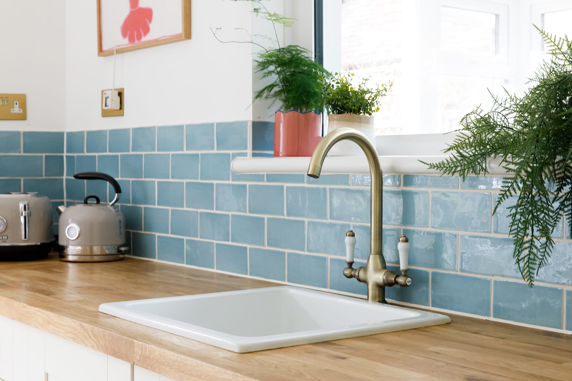 Pretty blue tiles and house plants line the kitchen.