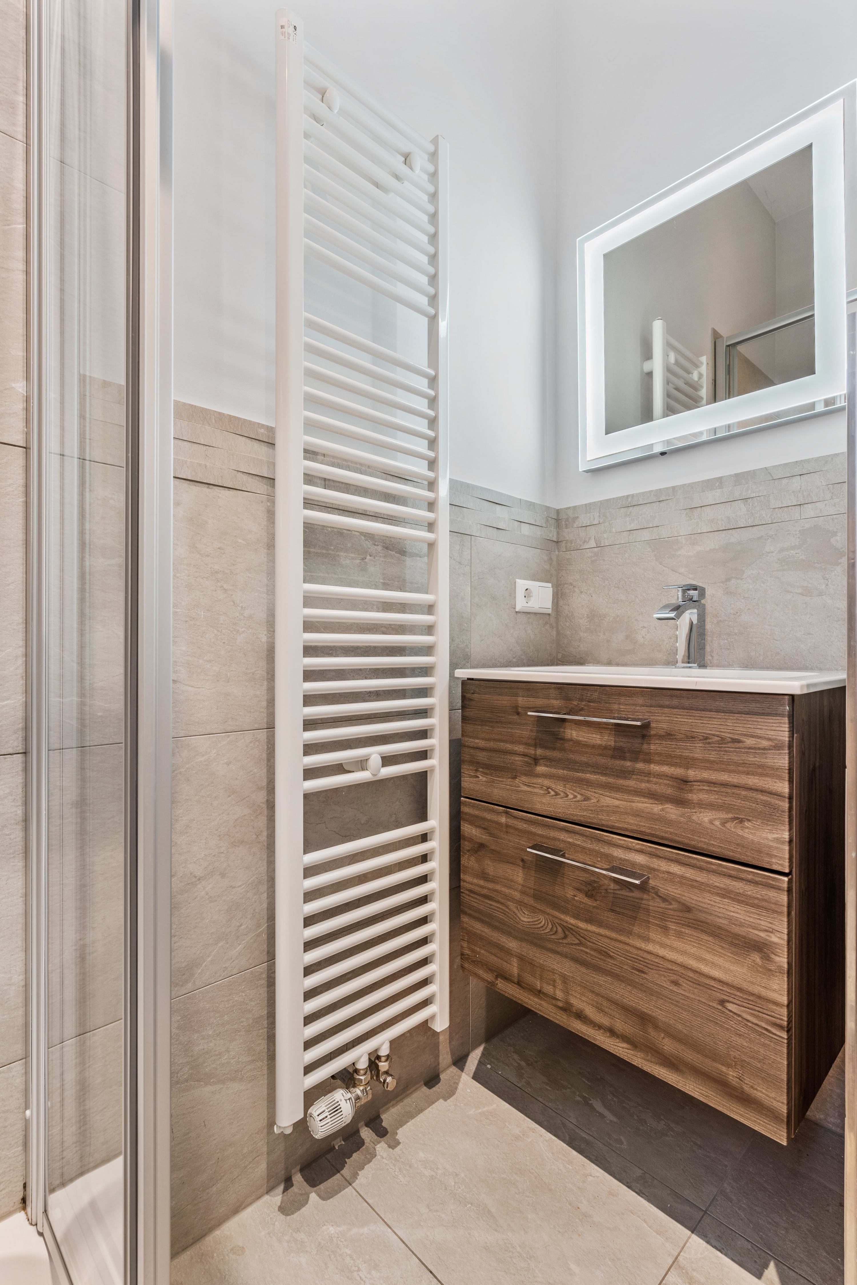 Refresh in a modern bathroom with chic fixtures and a touch of natural wood. Direct bookings: www.arcaproperties.lu