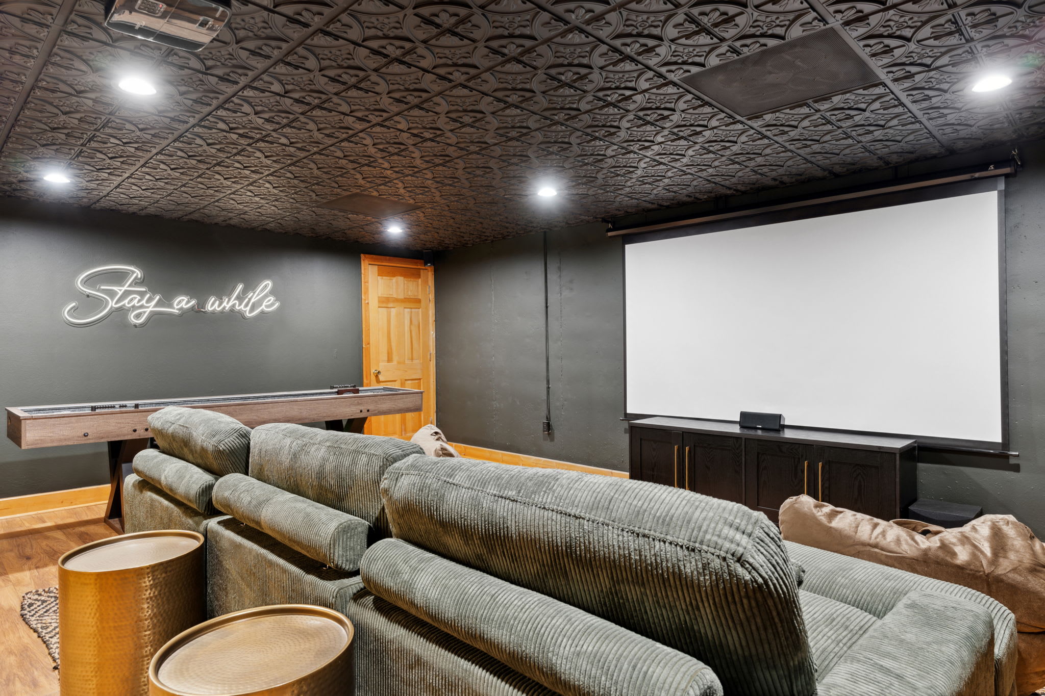 Movie Theater with a seriously comfy and way oversized couch. Bean bags for more seating up front and a legit movie screen. Shuffleboard, Darts, Scrabble, and mini basketball