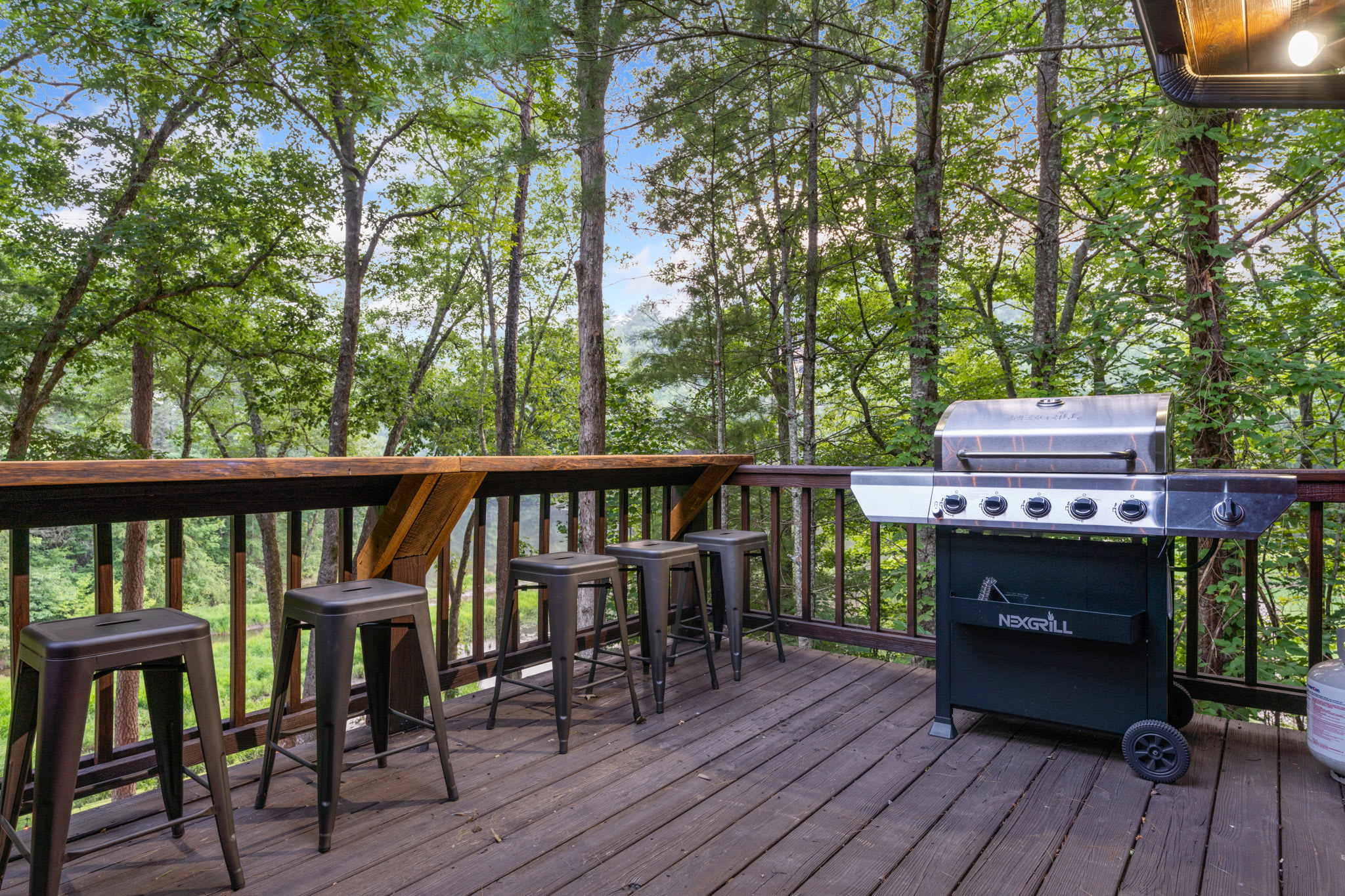 This is just the corner of one of our very large back decks. Lots of bar top seating overlooking the wooded backyard and Allen Lake. Fire up the new Nexgrill- always loaded with propane, ready to go for the grill master to entertain.