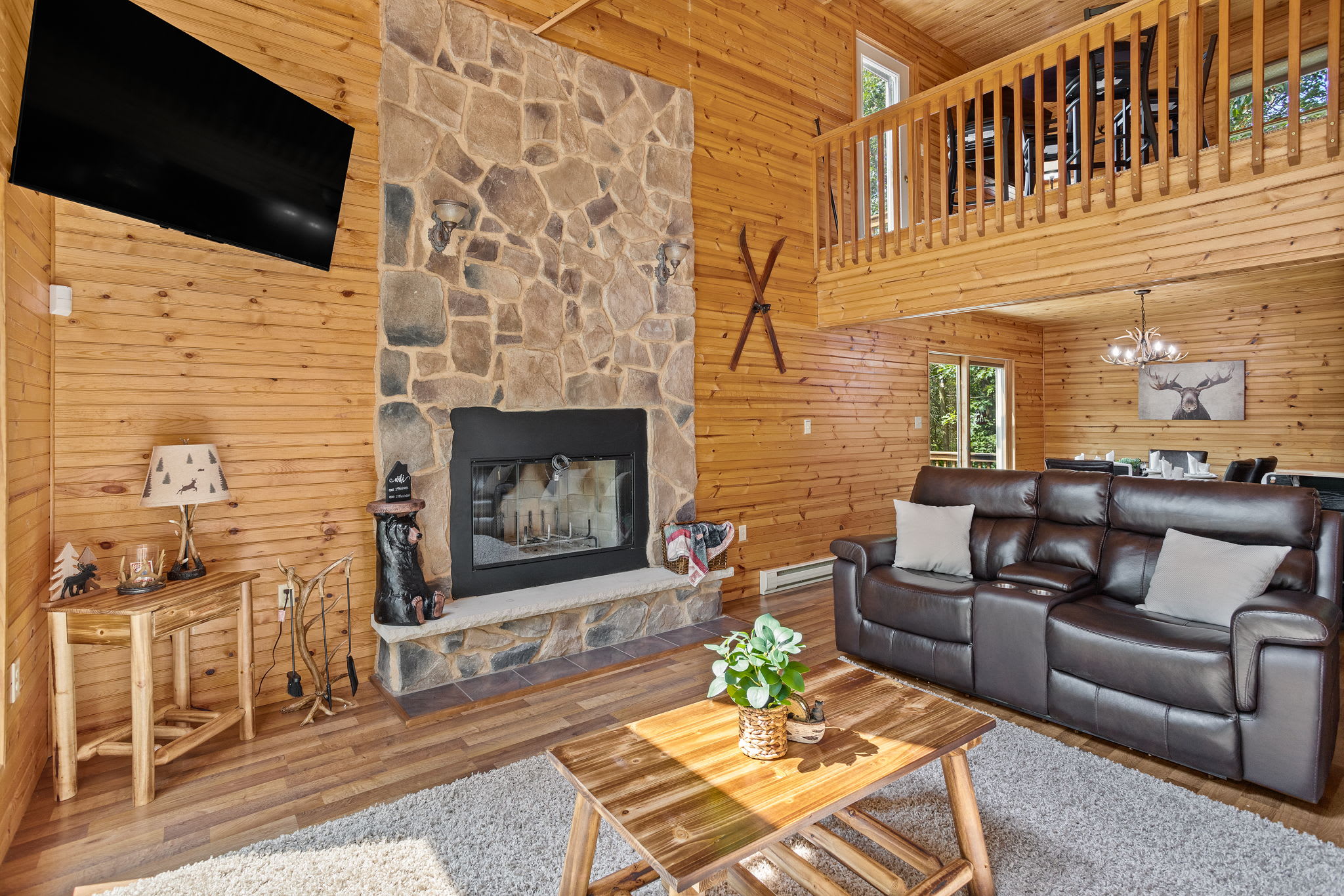 Featuring a striking stone fireplace, open lofted ceilings, and rich wood finishes, this living space is the perfect mix of rustic charm and modern comfort.