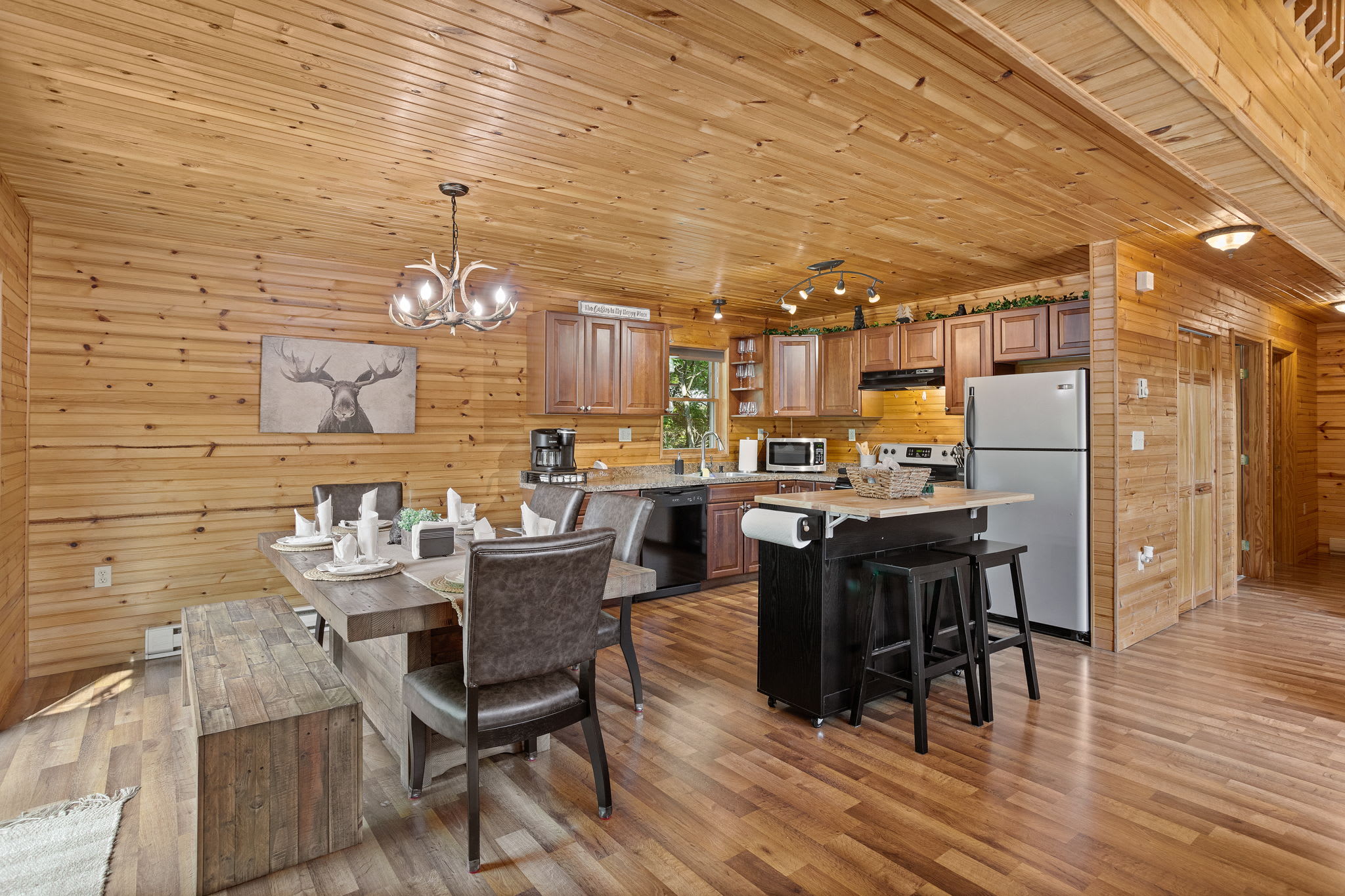 This beautifully set dining space, complete with a rustic wooden table and modern lighting, is perfect for sharing meals with family and friends.