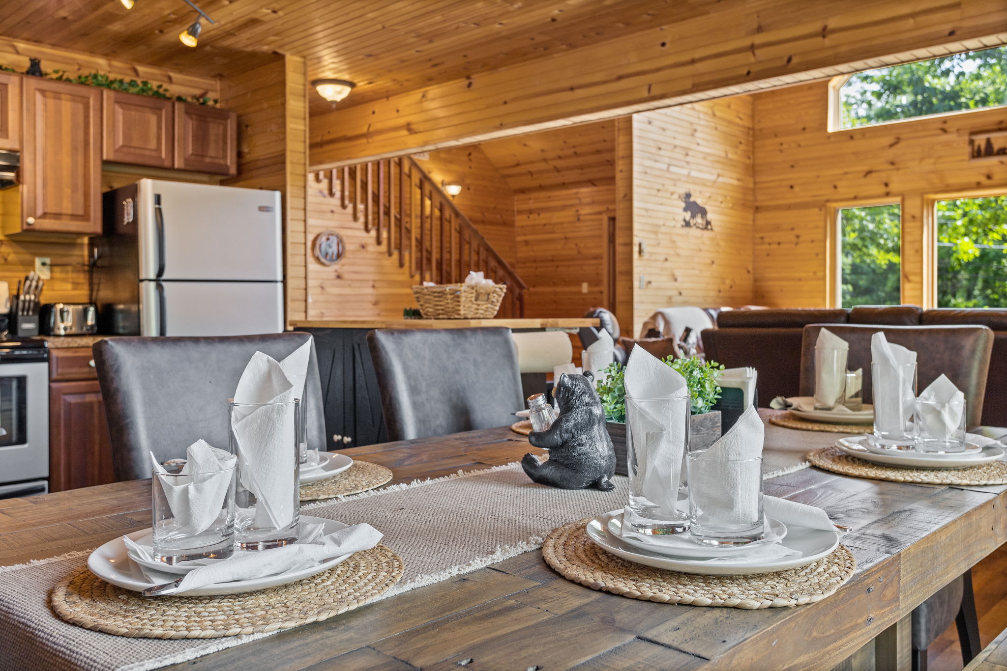 Elegant place settings, a rustic wooden table, and cozy cabin charm make every meal feel special in this inviting space.