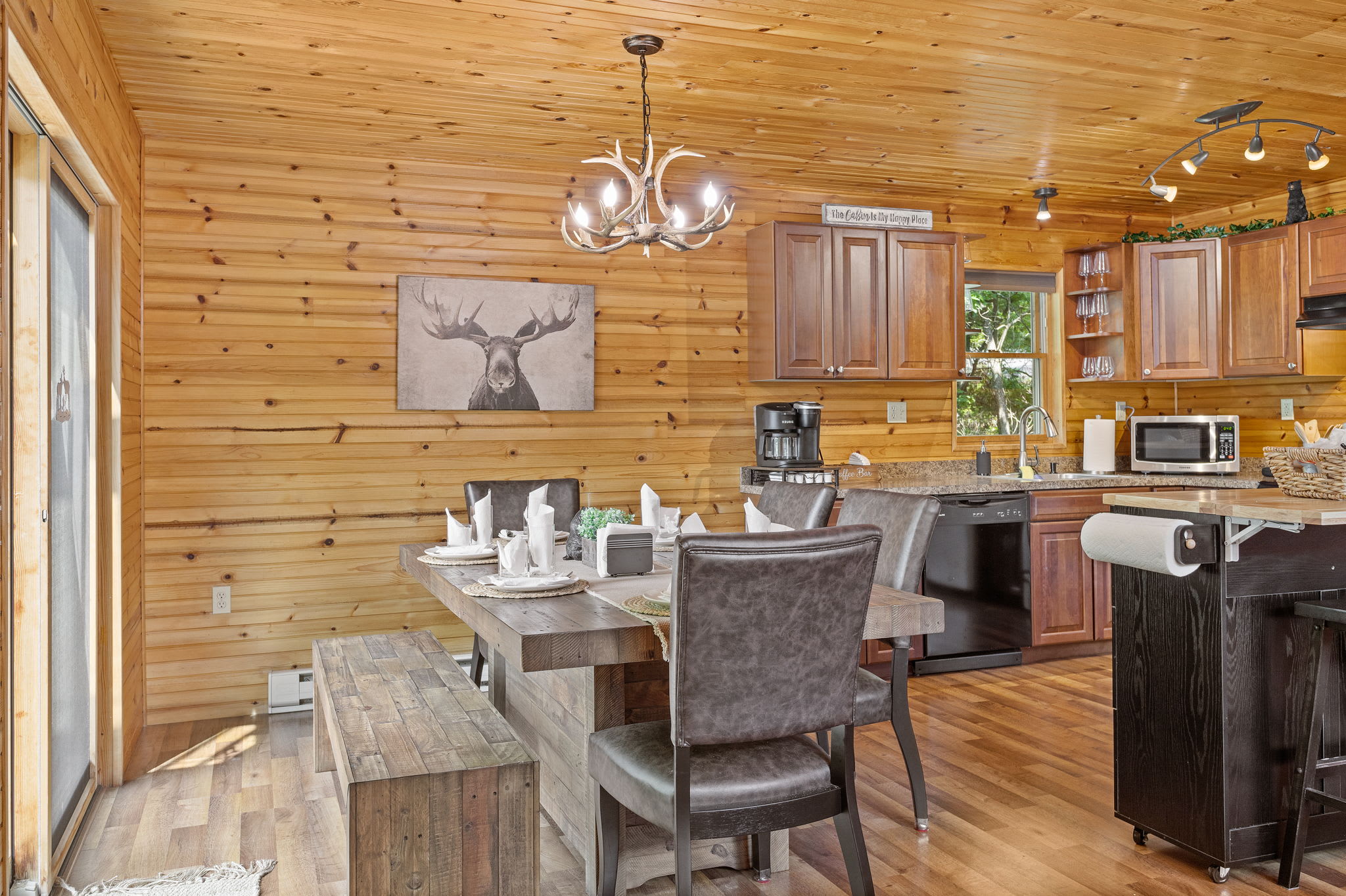 Rustic Elegance in the Dining Area, a beautifully set wooden table, modern lighting, and bench seating create the perfect spot for shared meals and good conversation.