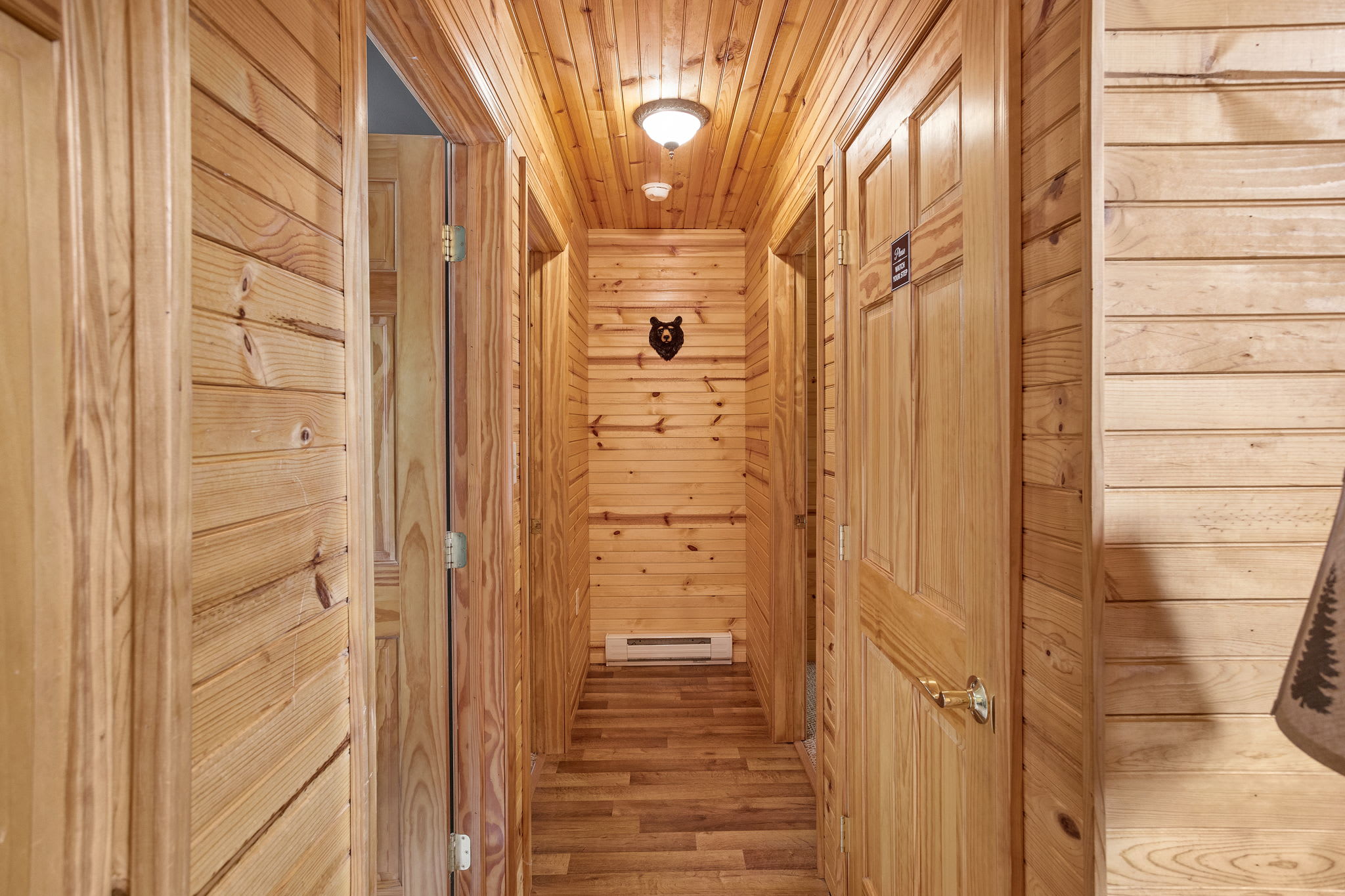 Cozy Cabin Hallway, the warm wood-paneled hallway leads to a peaceful retreat, with charming rustic décor adding to the cozy ambiance.