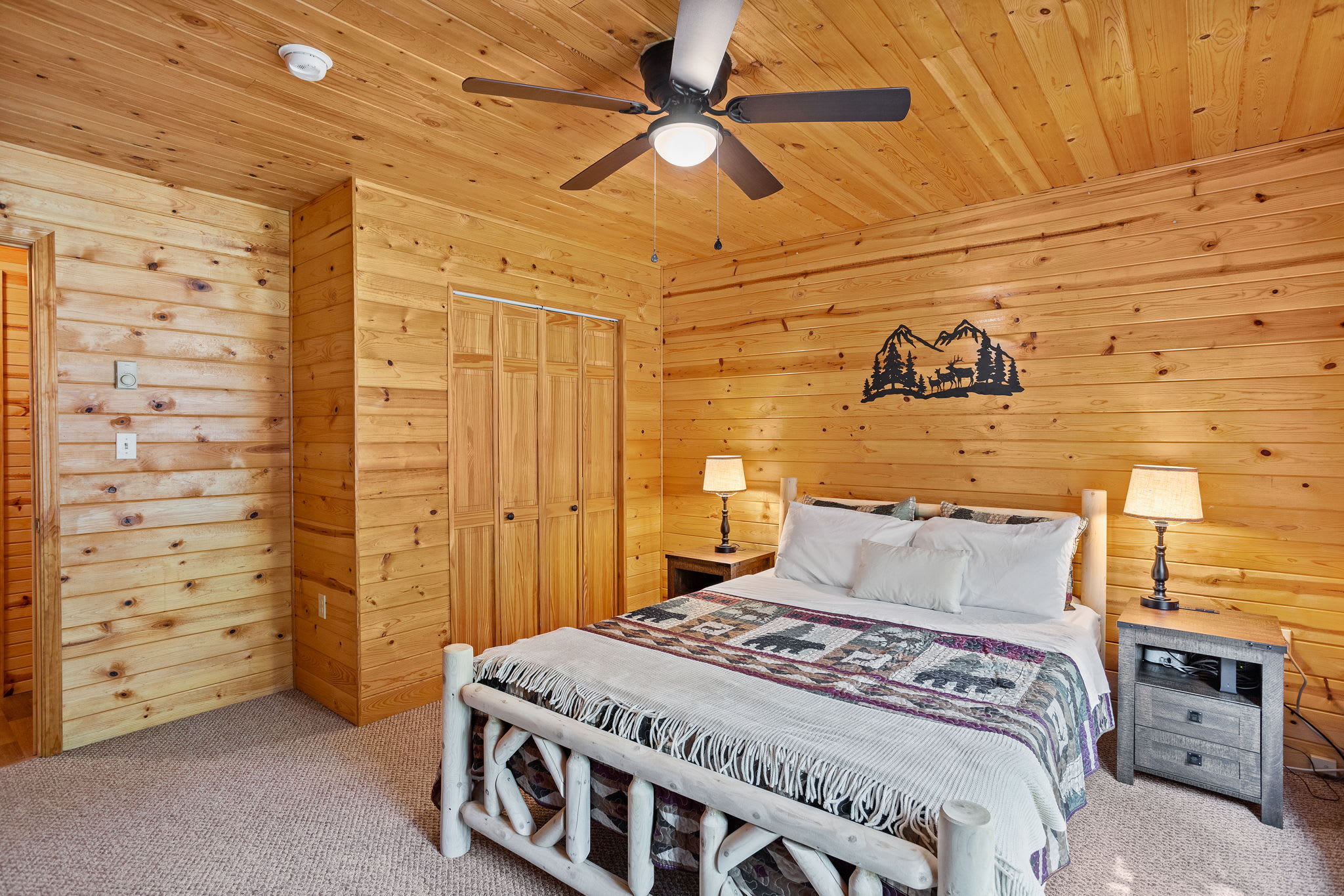 Featuring a handcrafted log bed frame, warm wooden walls, and plush bedding, this bedroom is designed for ultimate comfort.