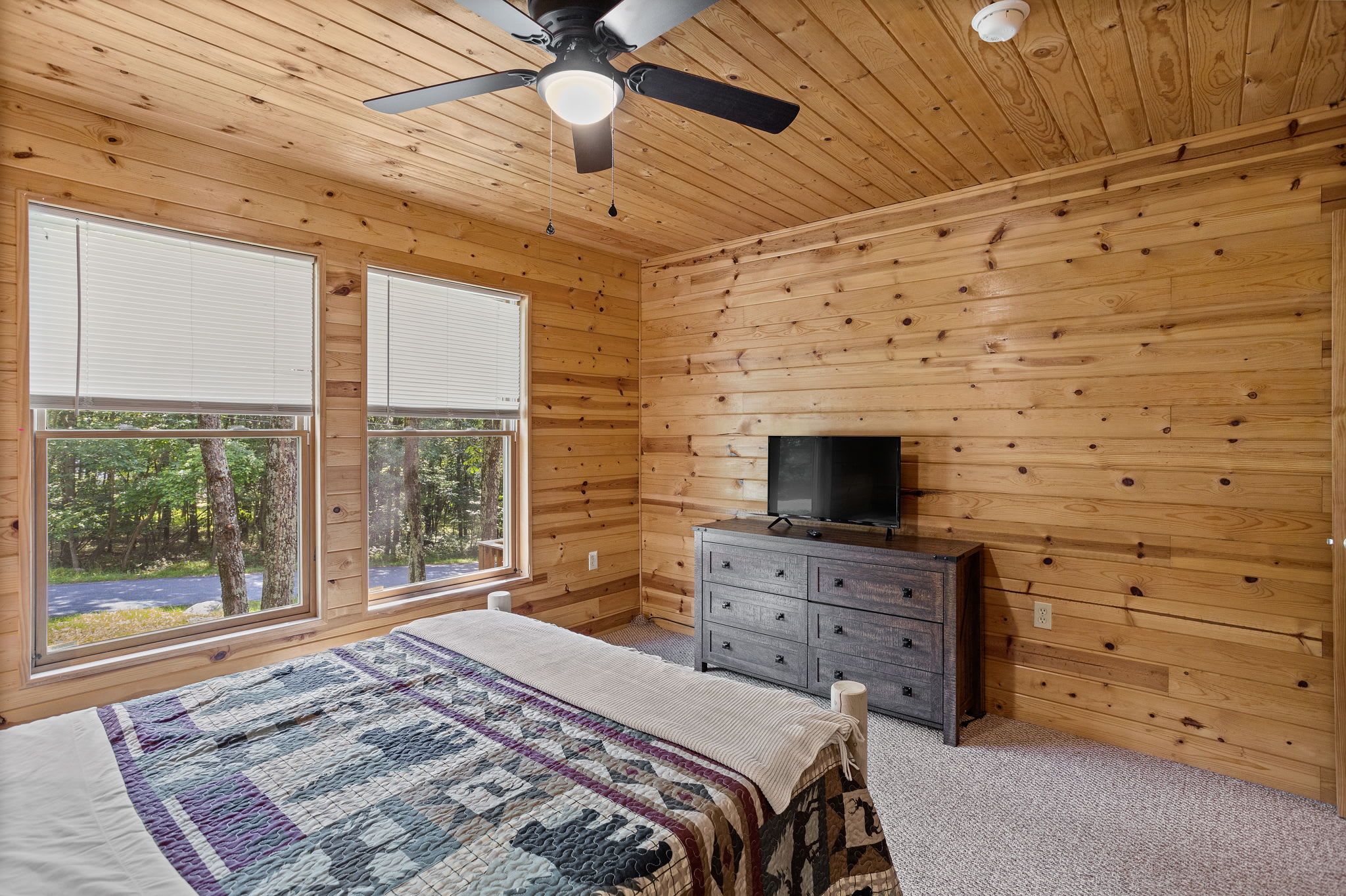 With large windows bringing in natural light and a TV for entertainment, this bedroom is the perfect balance of relaxation and convenience.