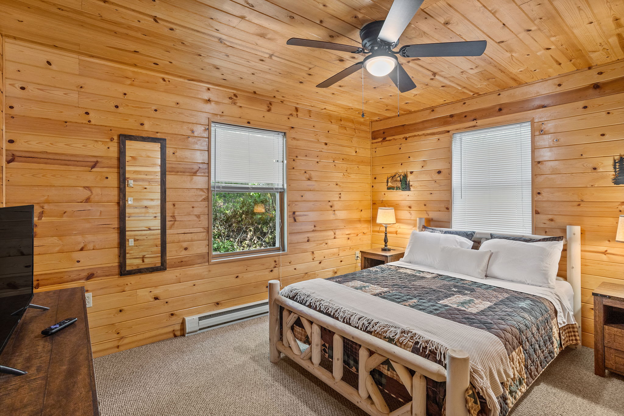 This inviting bedroom features rustic décor, a charming log bed, and ample natural light for a warm and homey feel.