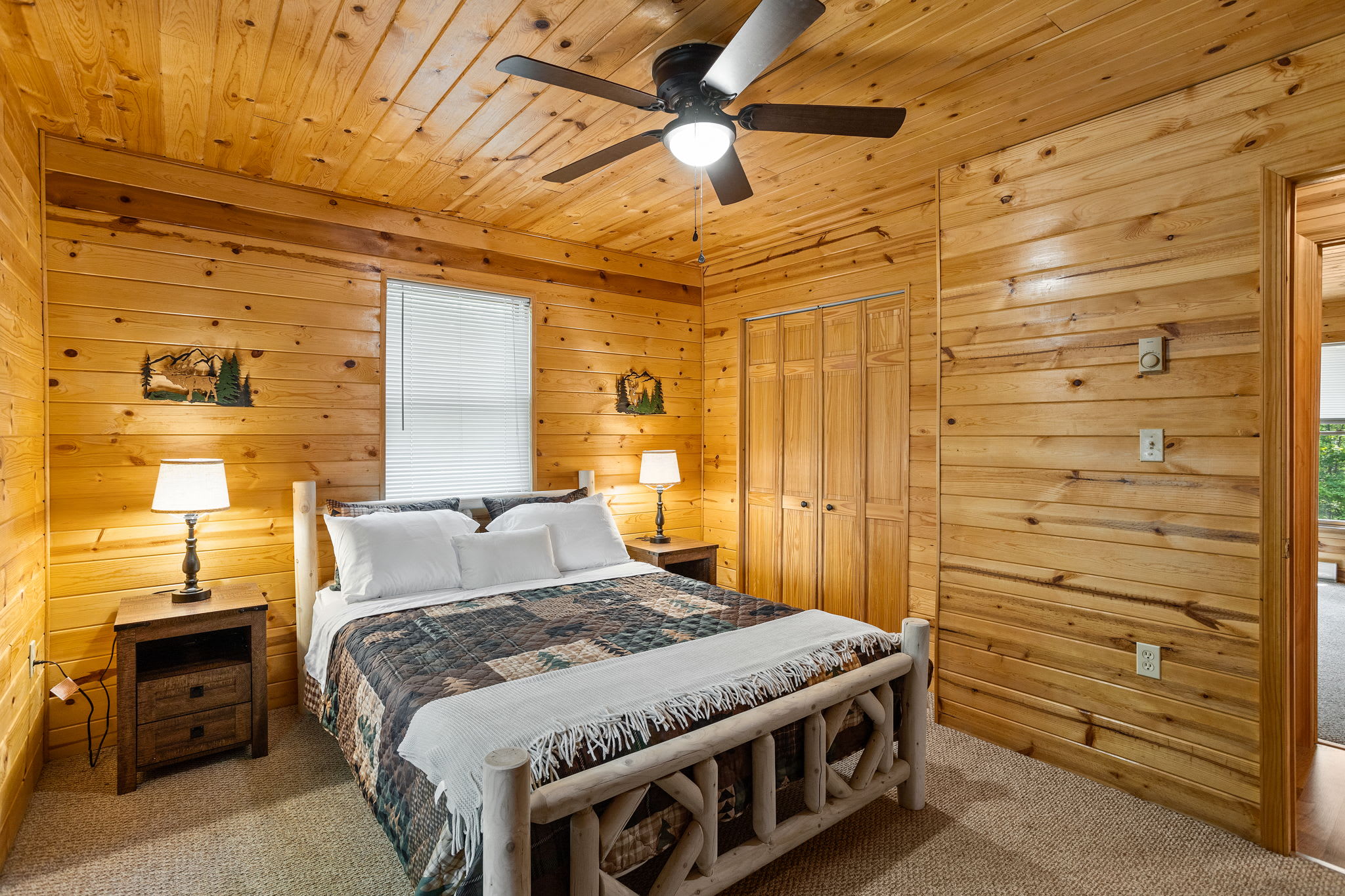This warm and inviting bedroom features a handcrafted log bed, soft lighting, and cozy bedding, making it the perfect place to unwind.