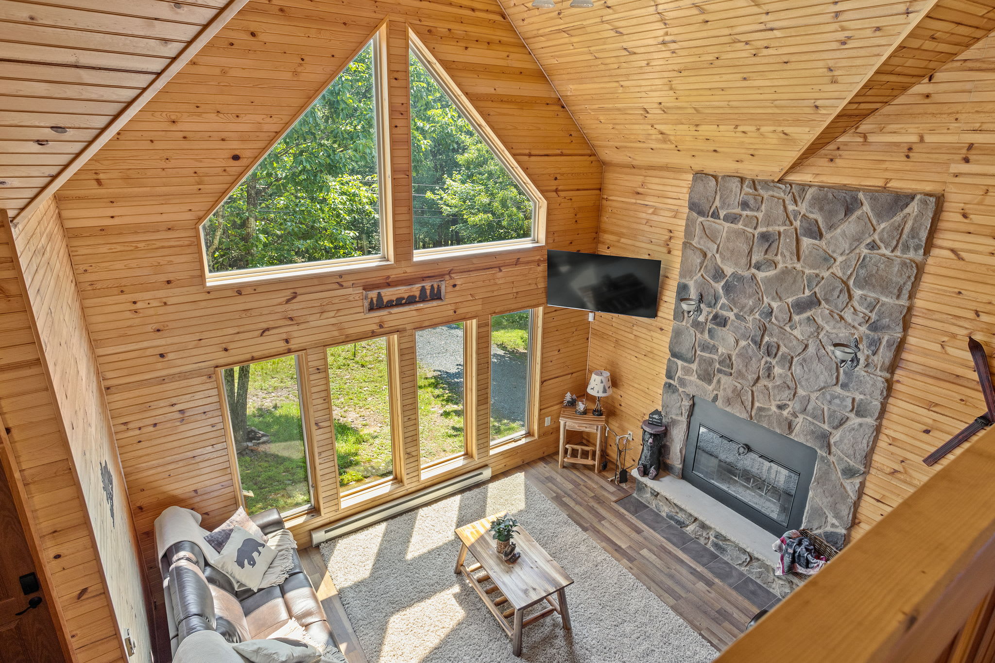 The stunning floor-to-ceiling windows flood this living space with natural light, offering a seamless connection between the indoors and the beauty of nature outside.