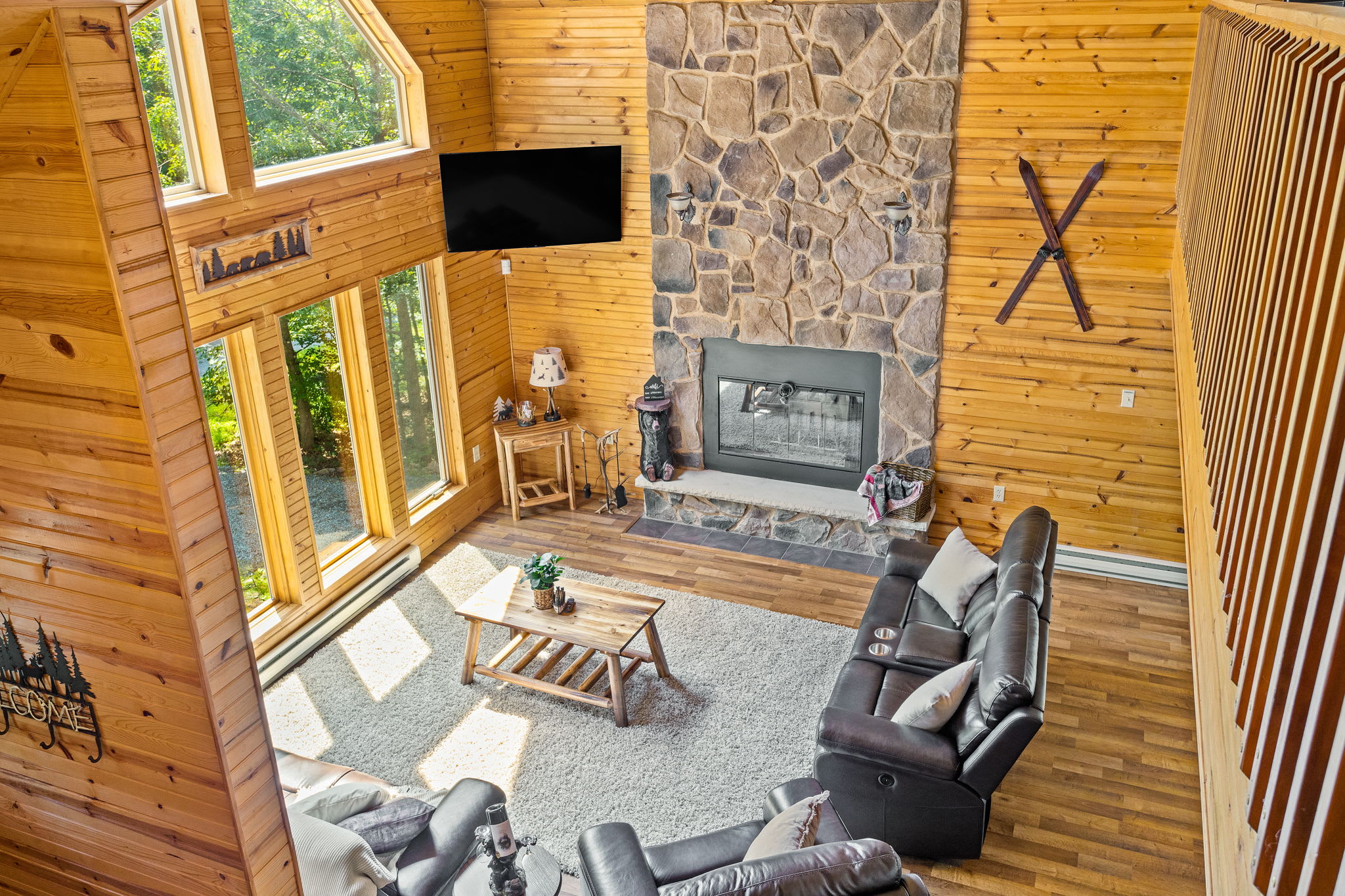 Overlooking the grand stone fireplace and expansive windows, this loft view showcases the heart of the home’s open-concept design.