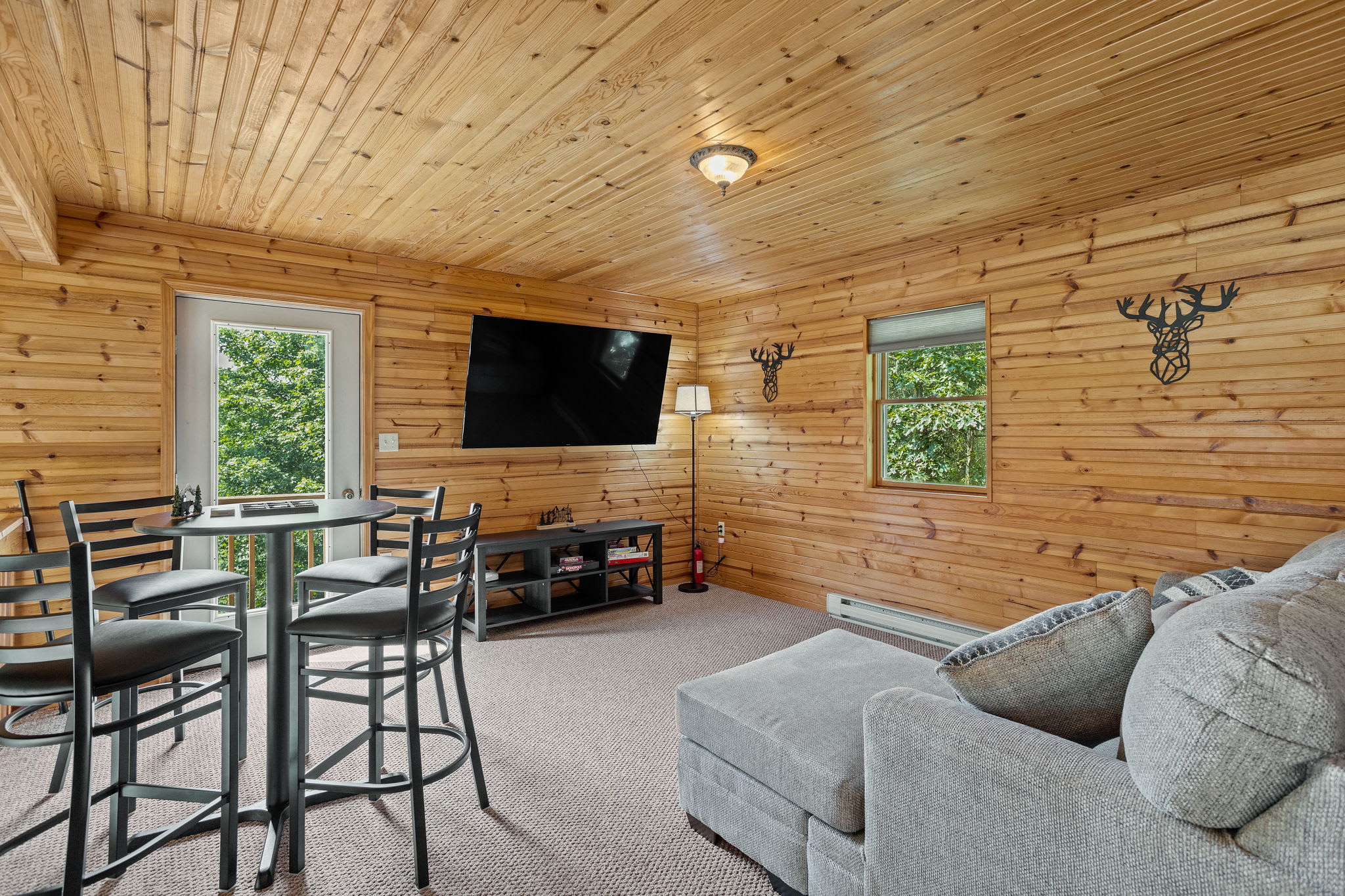 Unwind in this inviting lounge area, featuring a large sectional, high-top table, and a mounted TV for the perfect movie night or casual hangout.