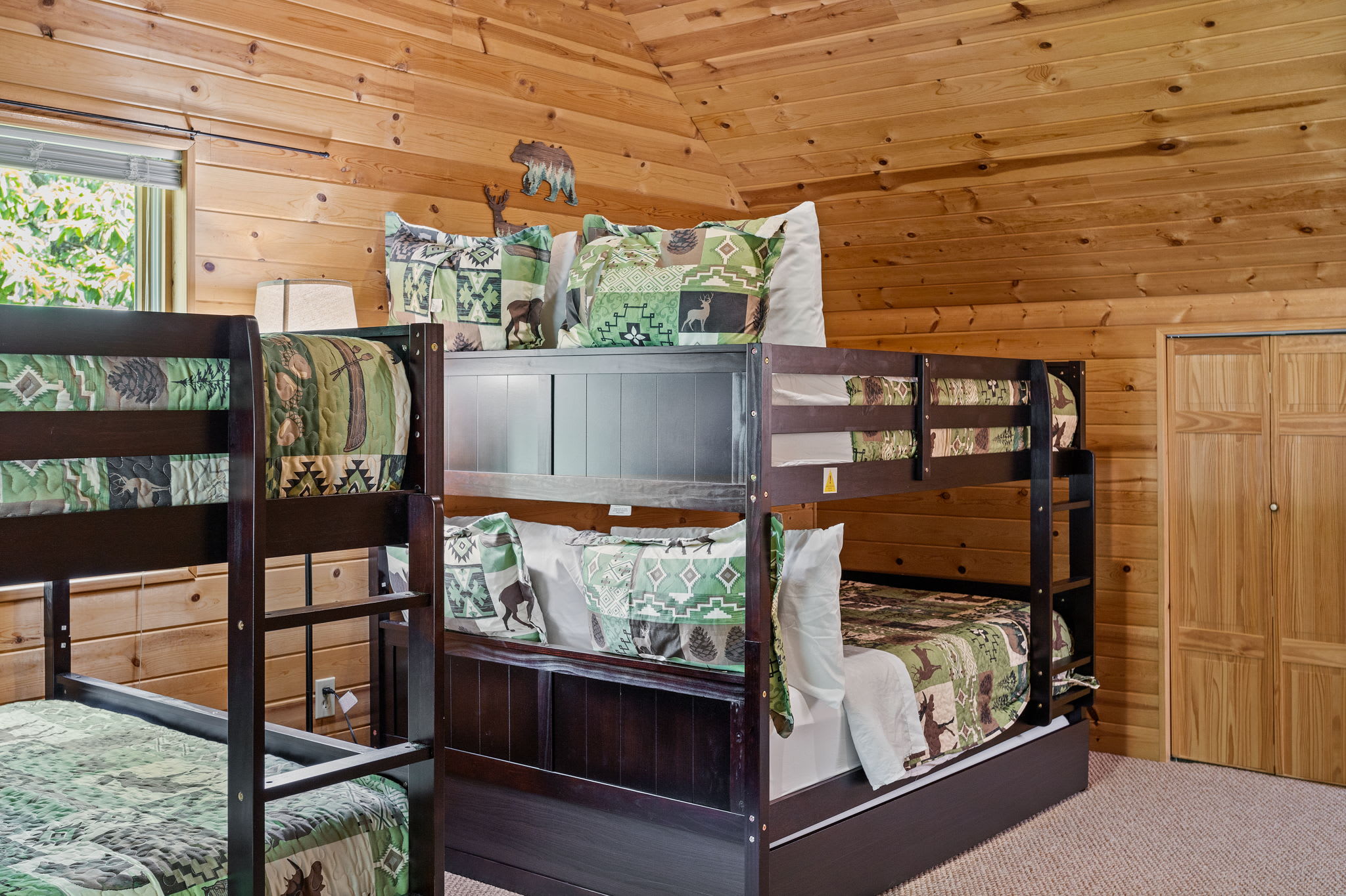 Designed for comfort and style, this room features two custom bunk beds, warm wooden walls, and soft lighting.
