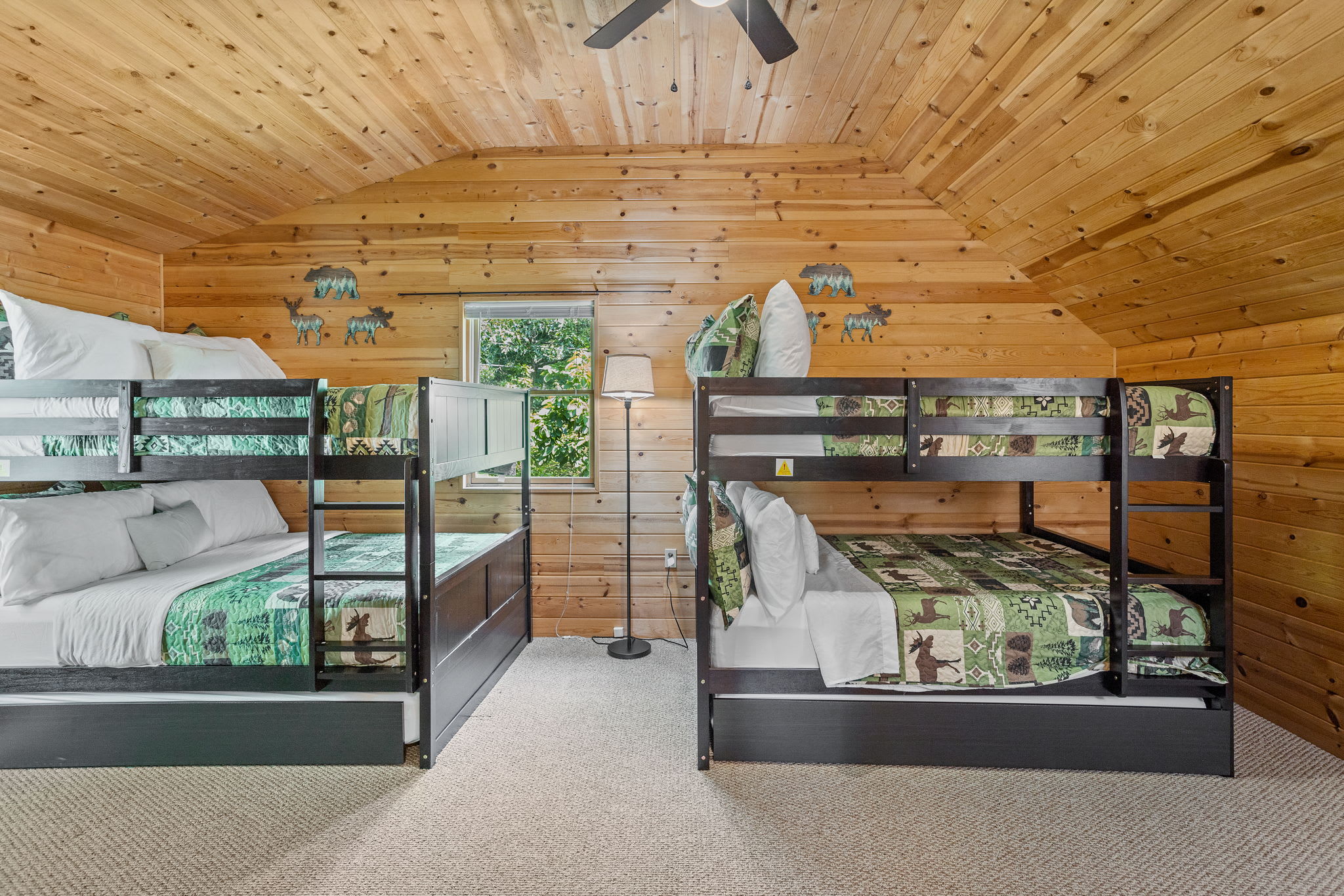 This inviting loft-style bedroom is perfect for families or groups, featuring two sturdy bunk beds with rustic woodland-themed bedding.