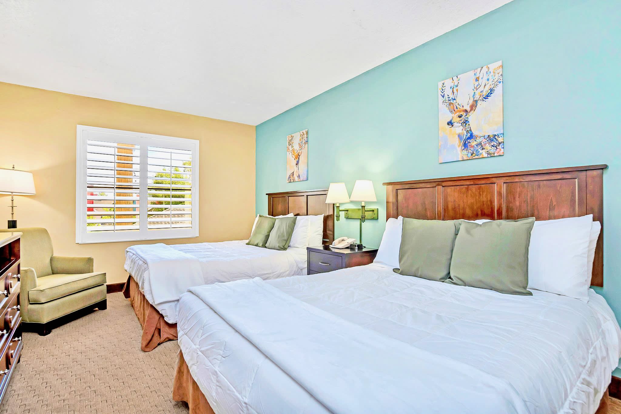 A Spacious Space With Comfortable Queen Beds And Natural Light