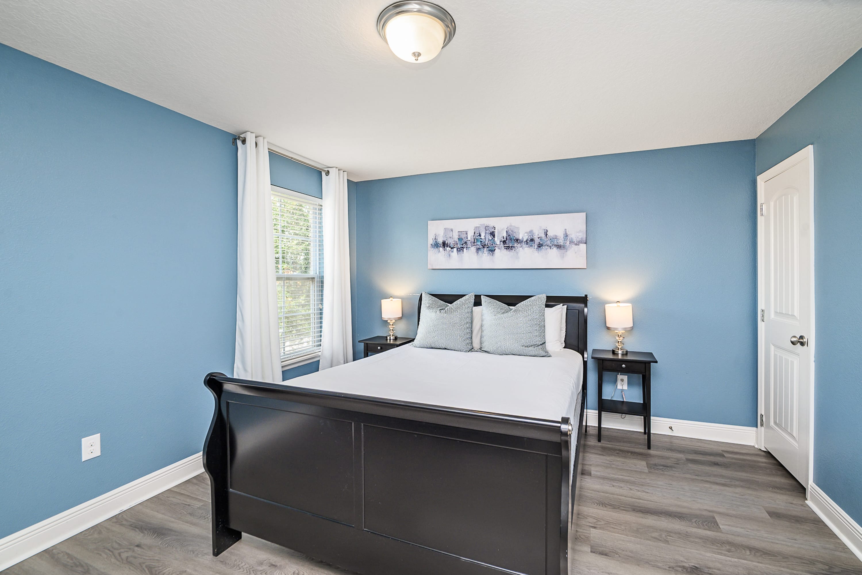 Relax In This Elegant Queen Bedroom With Soothing Blue Walls