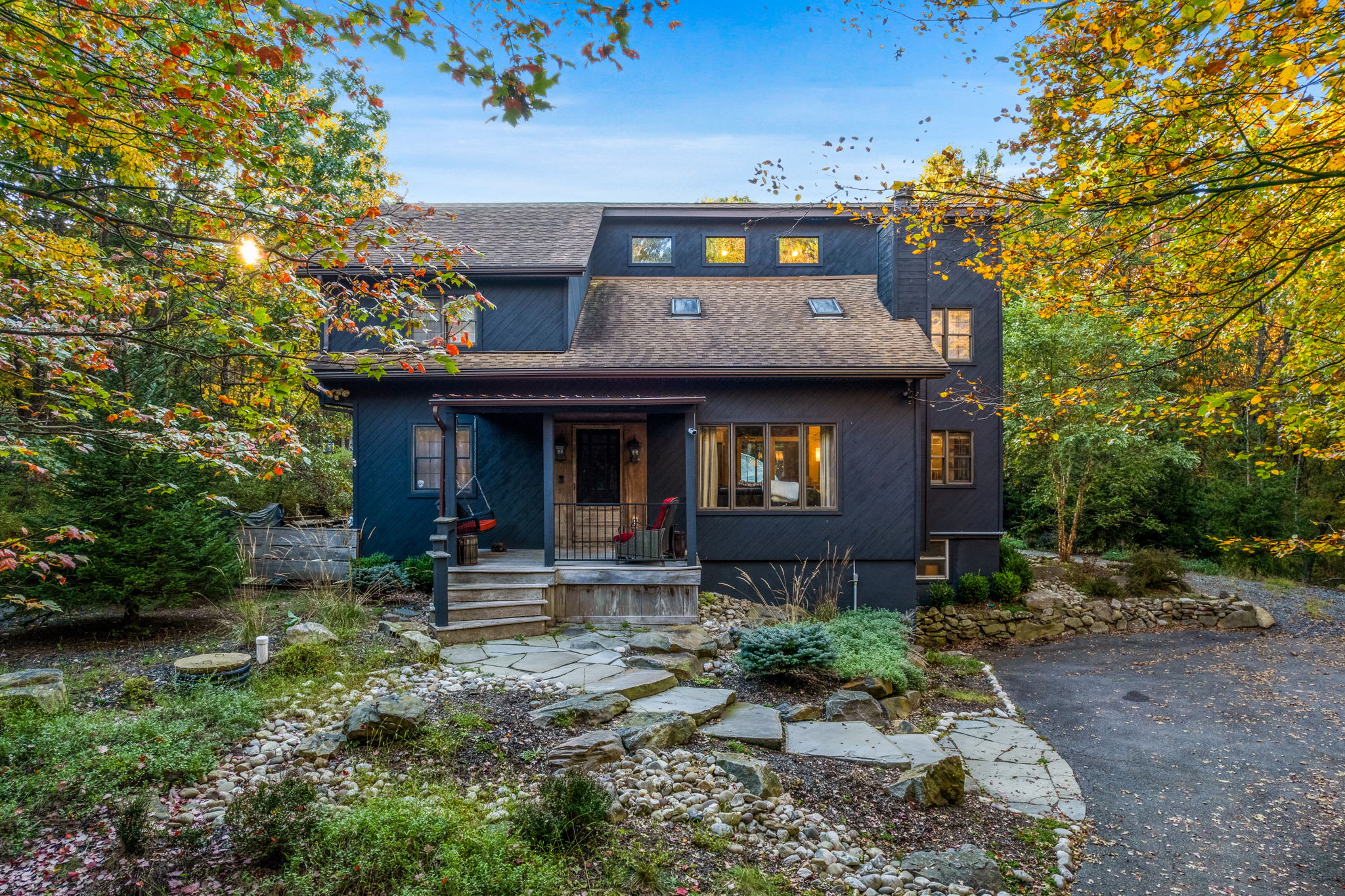 Front Entrance with Natural Charm – Surrounded by trees and stone pathways, this entryway sets a welcoming tone.
