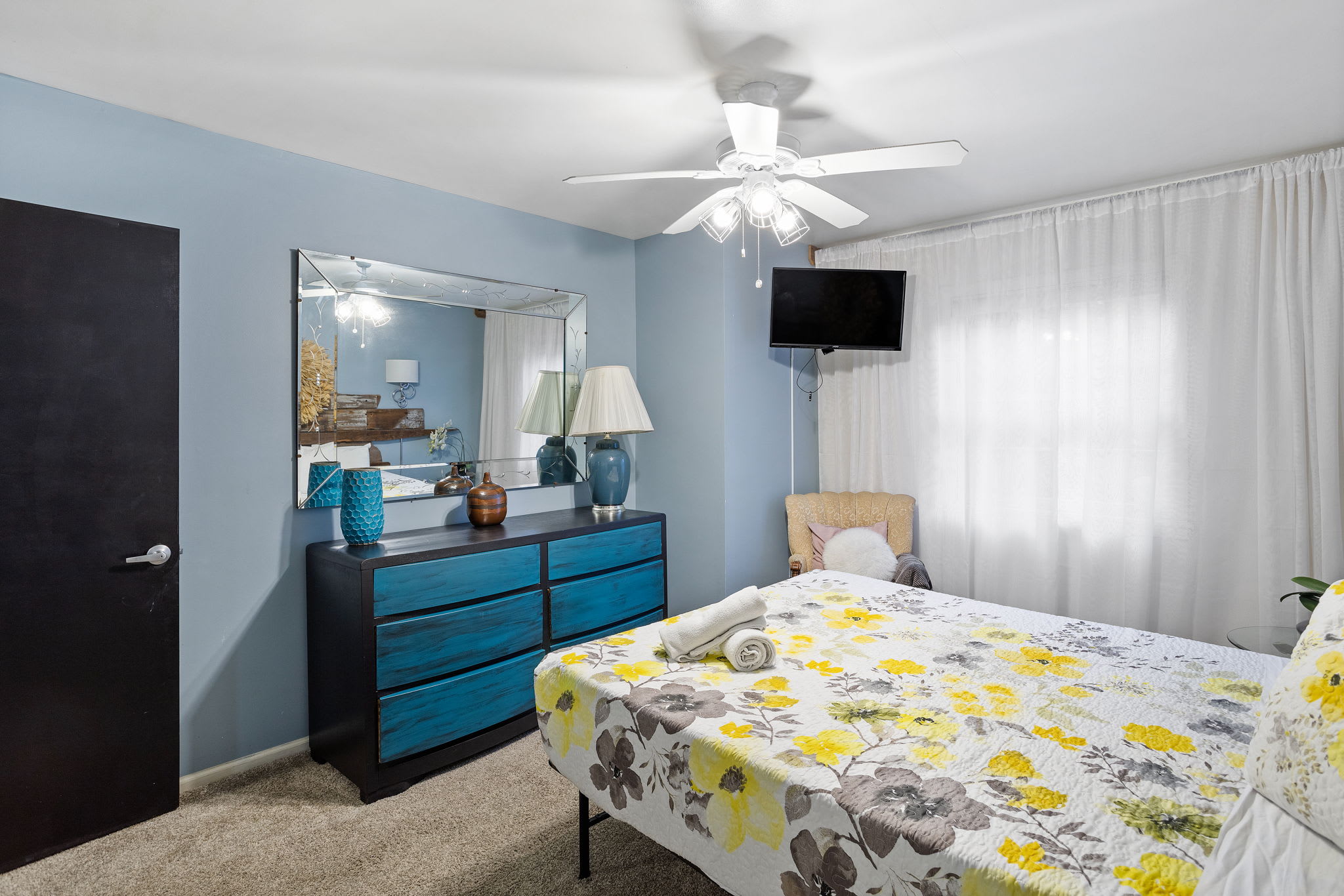 Thoughtful touches like the ceiling fan, comfy reading chair, and large mirror blend style with everyday comfort.