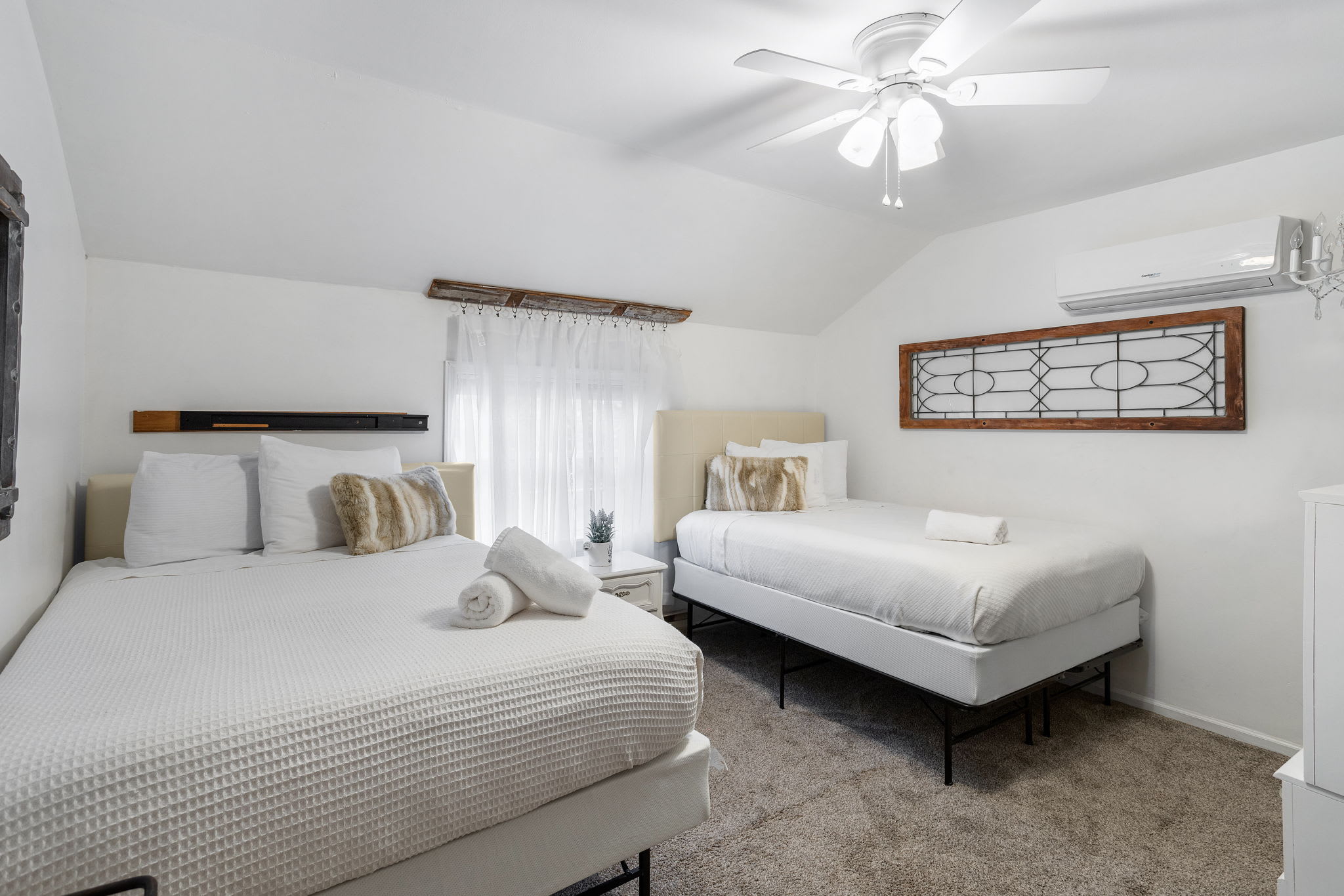 Bright white bedding and plush faux-fur accents create a tranquil, inviting space for a restful night.