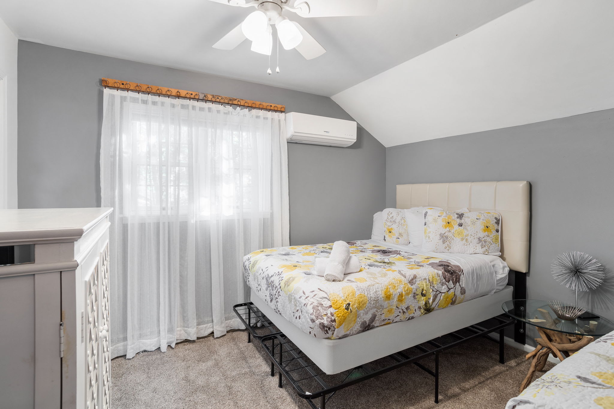Gentle daylight filters through sheer curtains, illuminating the neutral tones and creating a bright, airy ambiance.