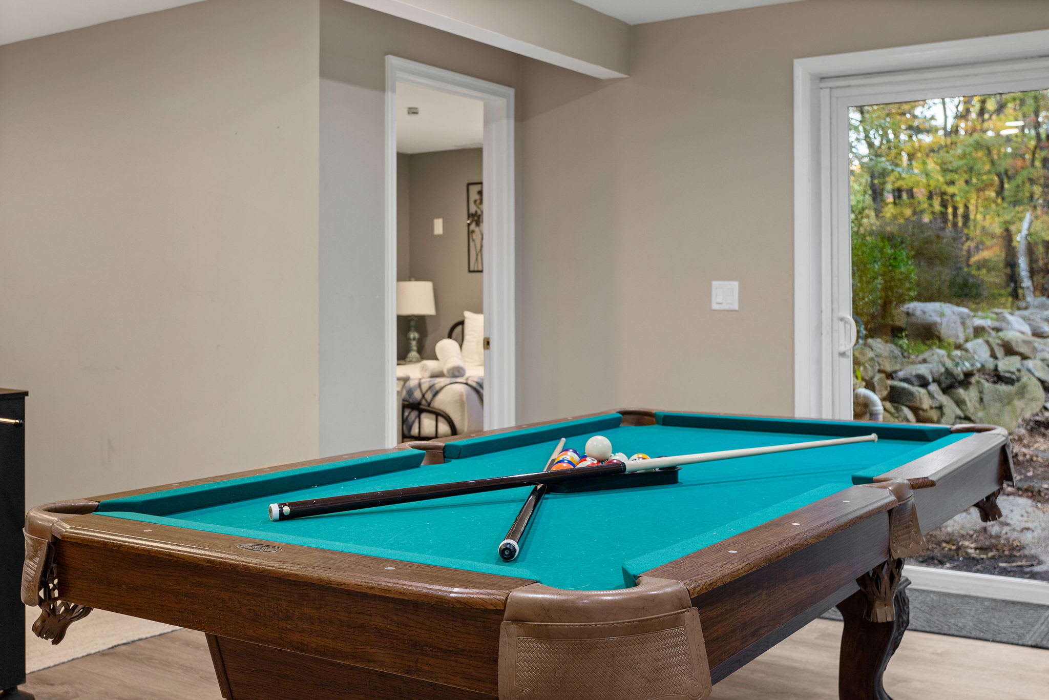A closer look at the pool table reveals sliding doors that lead to a natural rock landscape, blending indoor fun with a hint of the outdoors.