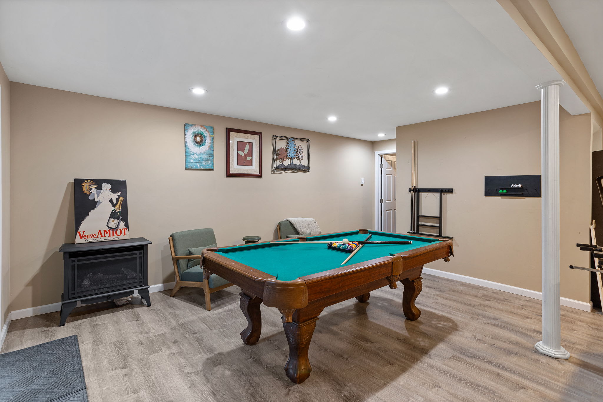 Wall art and cozy seating flank the pool table, creating a relaxed vibe perfect for friendly competition or laid-back hangouts.