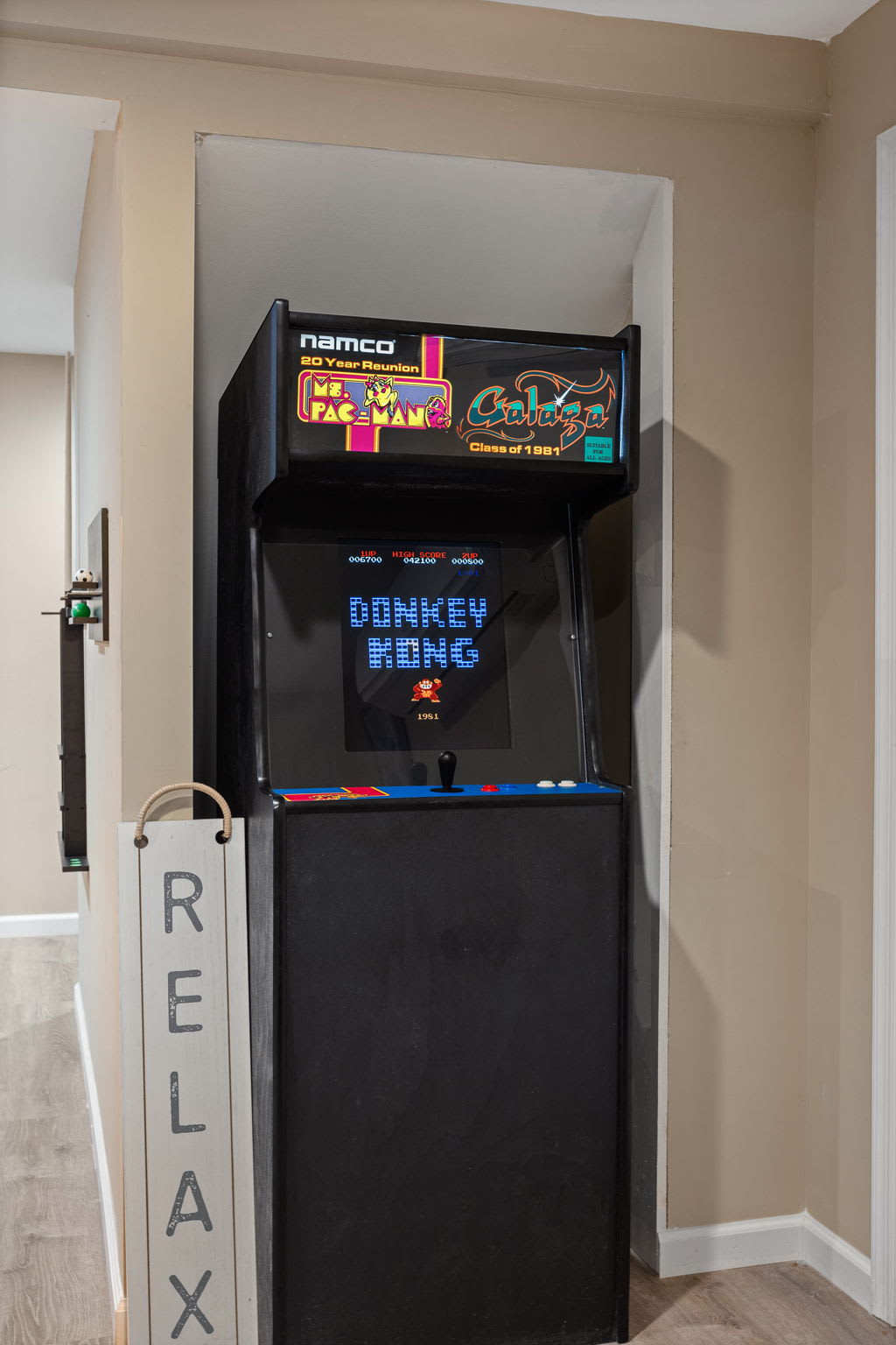 An old-school arcade cabinet, featuring classics like Donkey Kong and Pac-Man, adds a nostalgic finishing touch to this playful space.