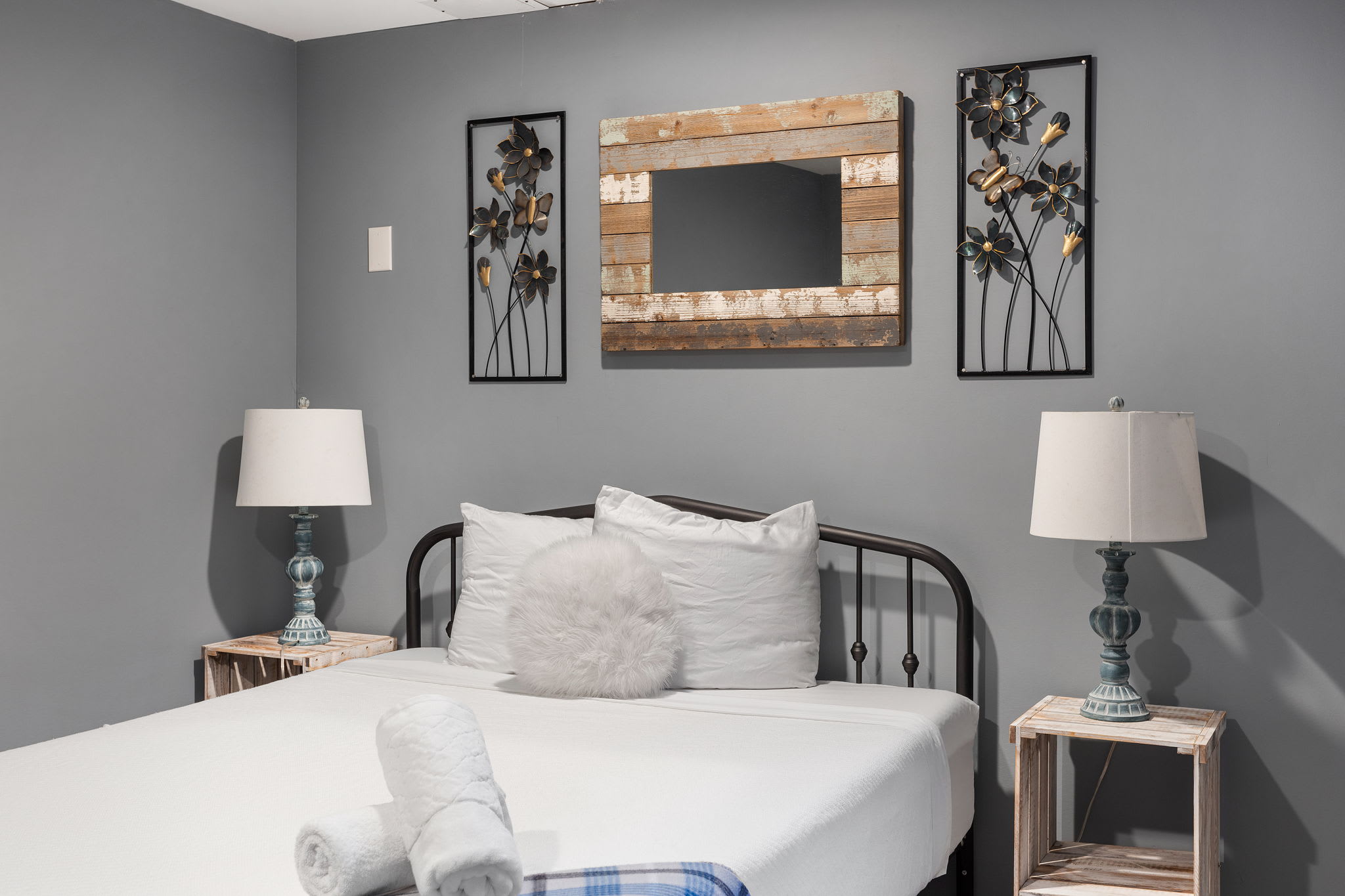 A closer look highlights the rustic wood mirror and artistic metal accents, bringing a hint of farmhouse charm to the modern setting.
