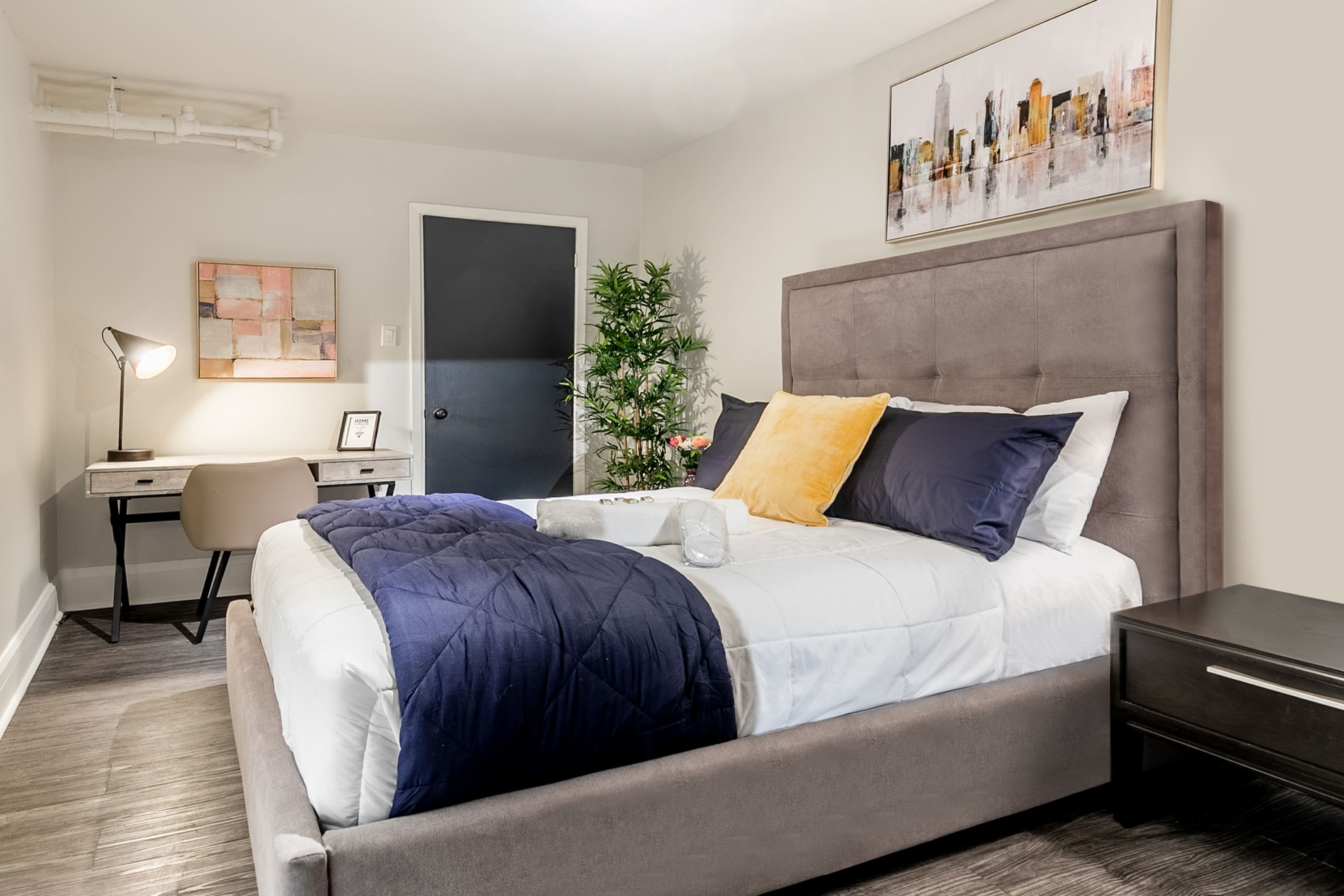 Elegant Bedroom With A Cozy Work Desk And Vibrant Decor