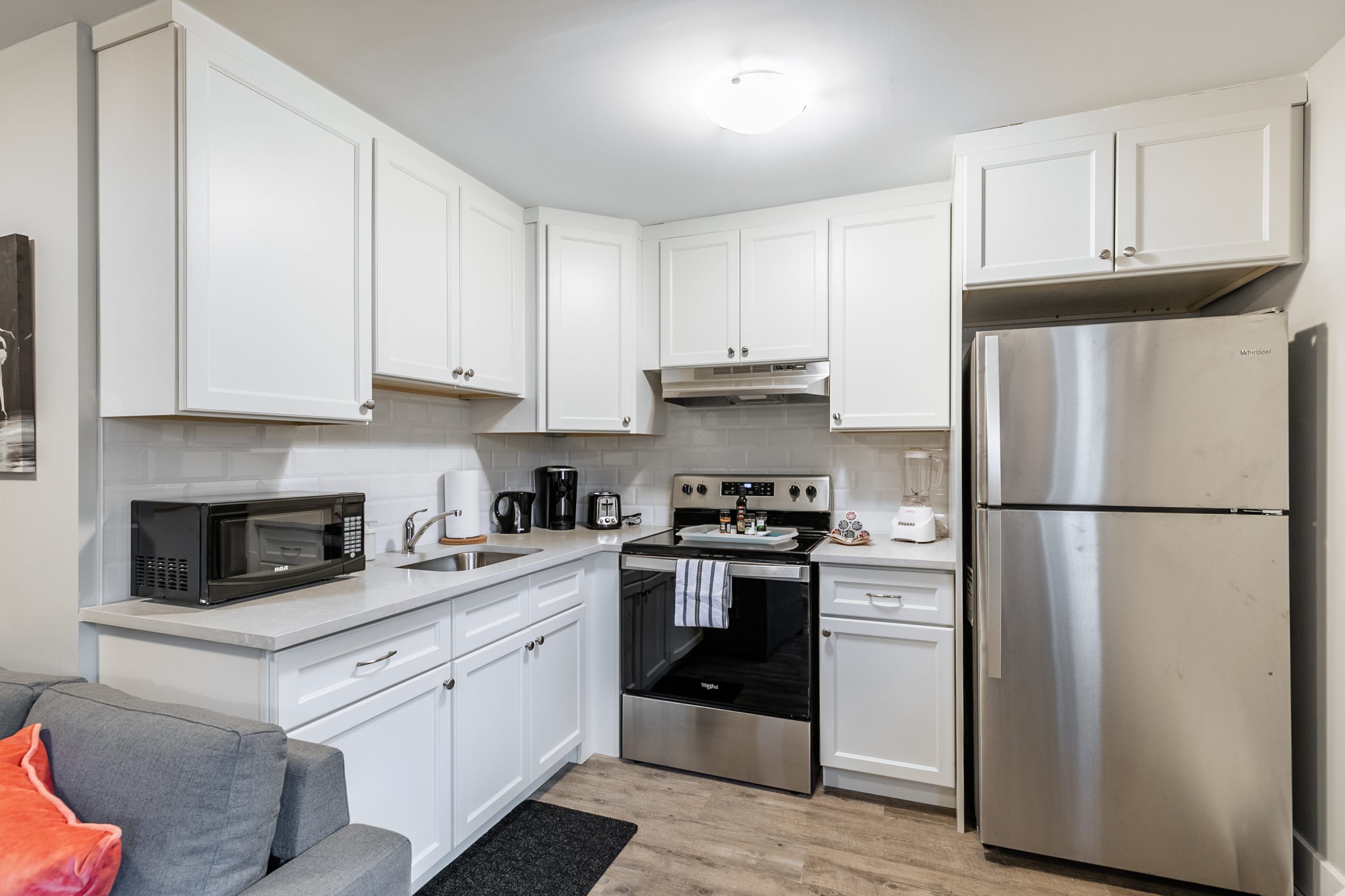 Fully Equipped Kitchen With Modern Appliances And Sleek White Cabinetry
