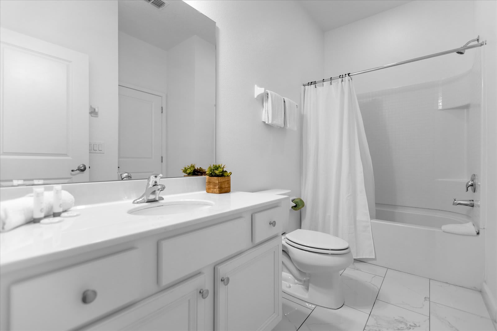 Bright And Elegant Bathroom Featuring A Bathtub And Clean White Finishes