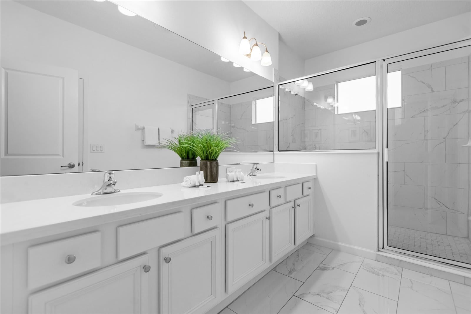Bright Bathroom Featuring A Double Vanity And Natural Decor Accents