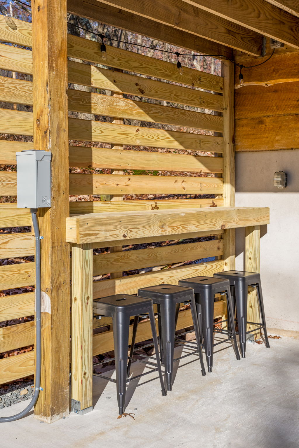 A beautifully crafted wooden bar with sleek black stools provides a great place to enjoy a morning coffee or an evening drink.