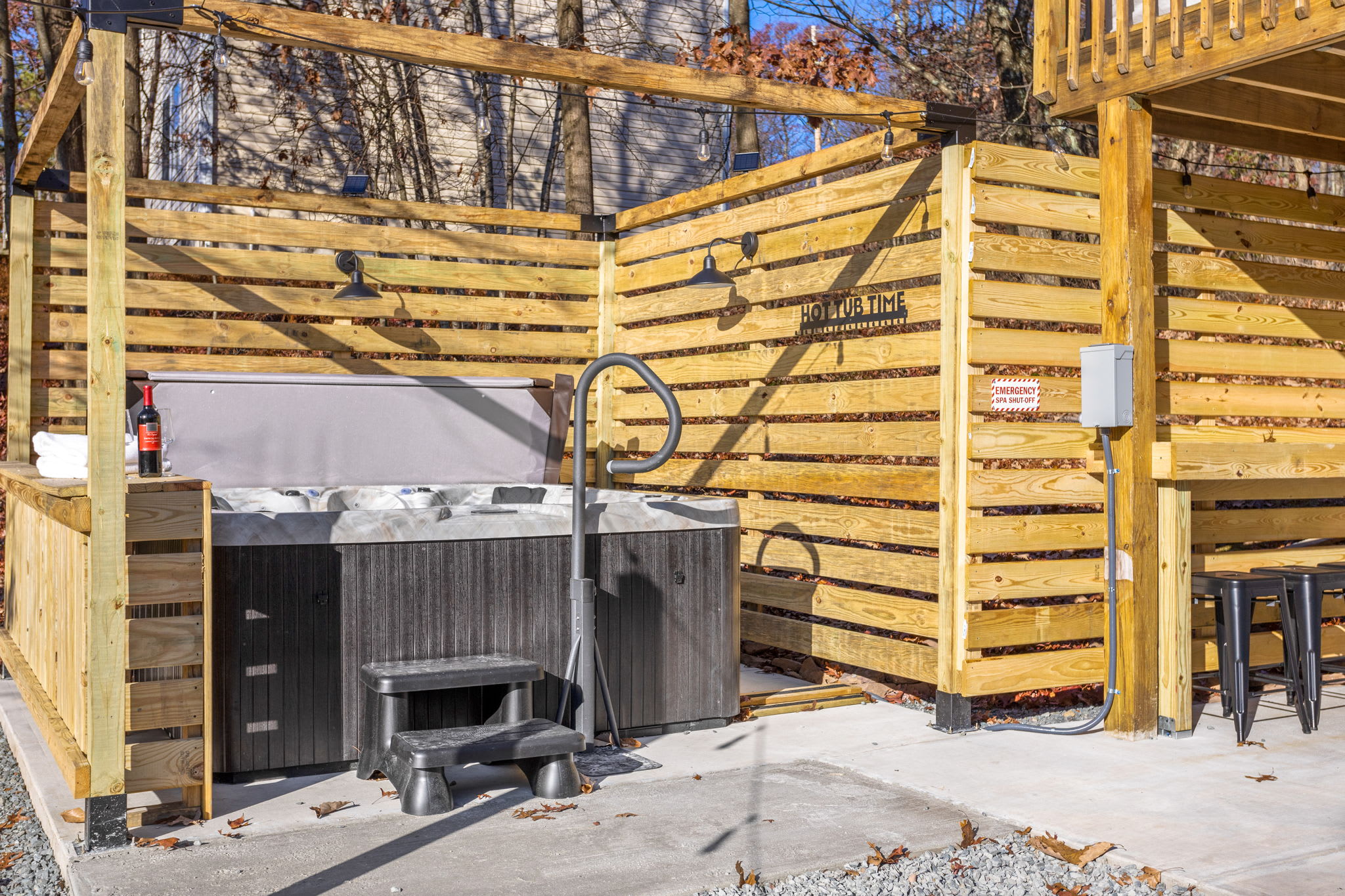 Nestled within a wooden privacy enclosure, this luxurious hot tub invites you to soak and unwind under the open sky.