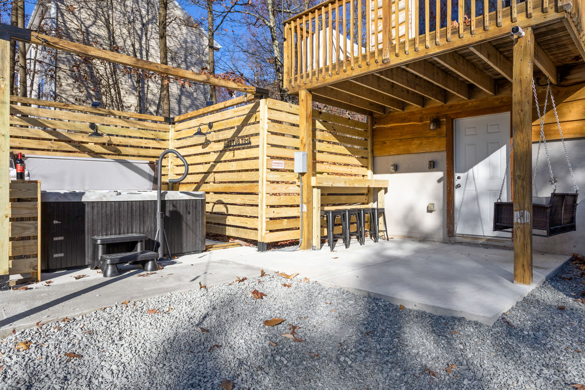 A seamless blend of a hot tub, bar seating, and a cozy swing makes this the ultimate outdoor relaxation area.