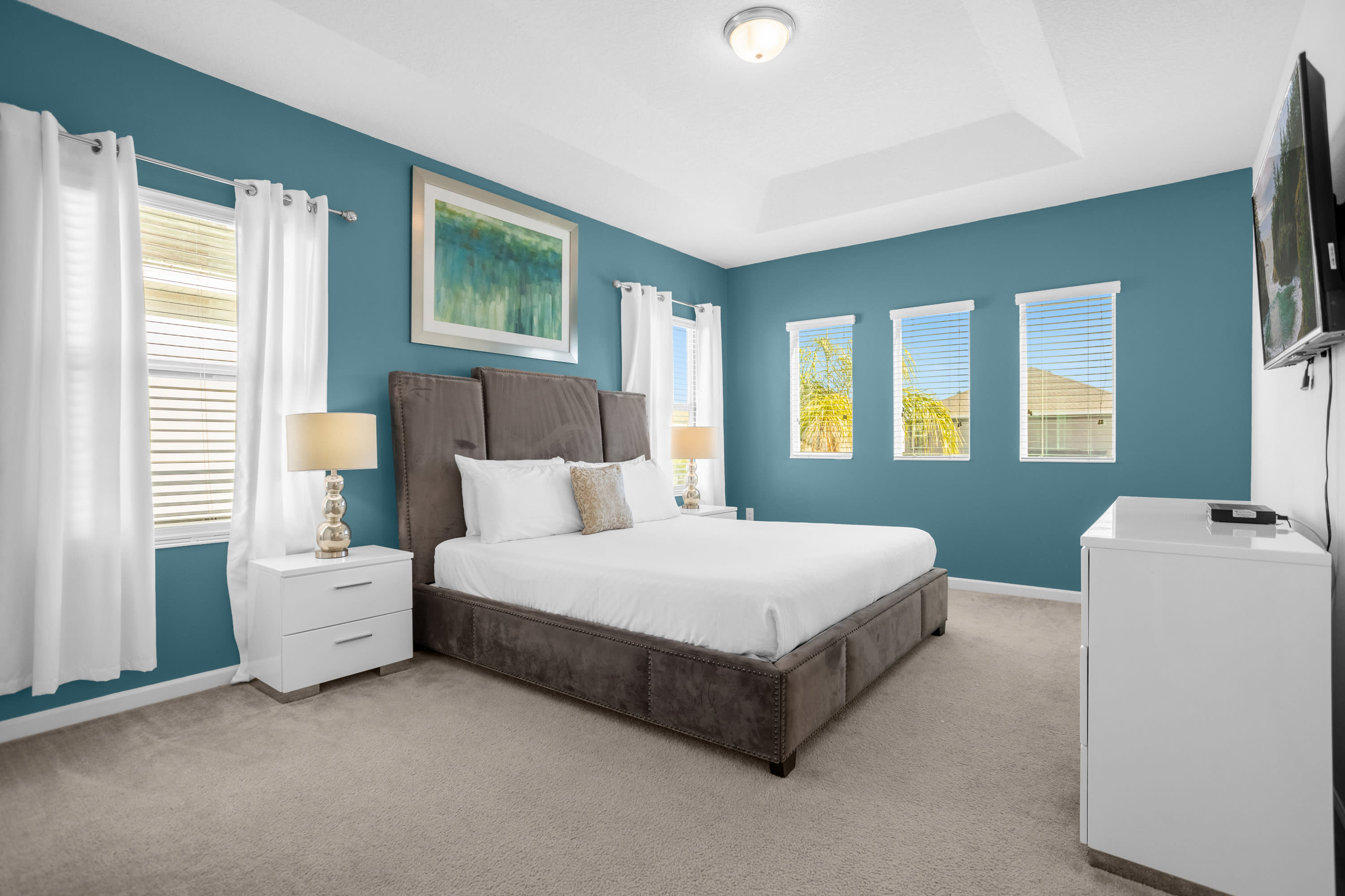 King Bedroom With Plush Bedding And Entertainment Setup