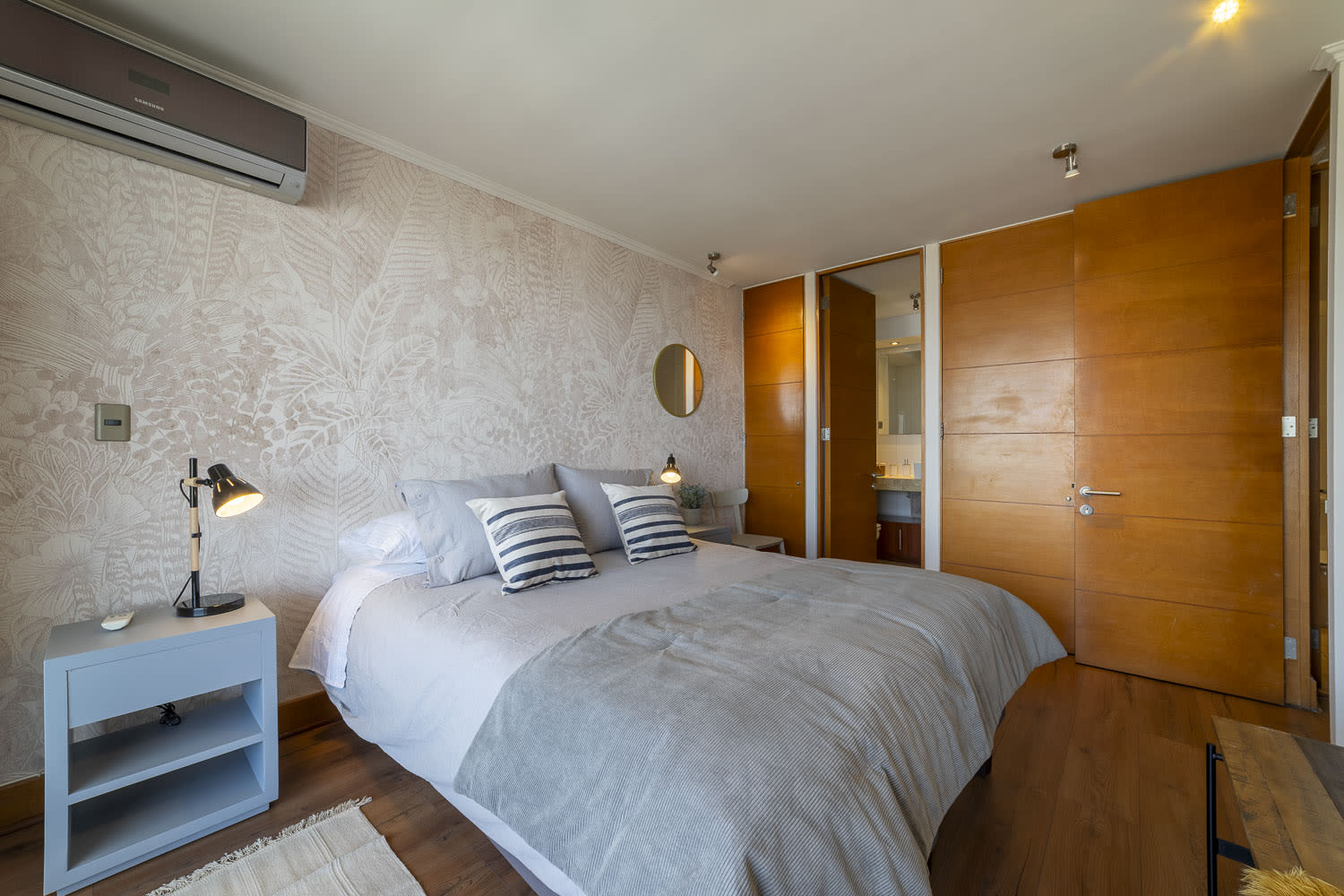 Relax in this cozy bedroom with modern decor, featuring a comfortable bed and ambient lighting, perfect for a restful stay.