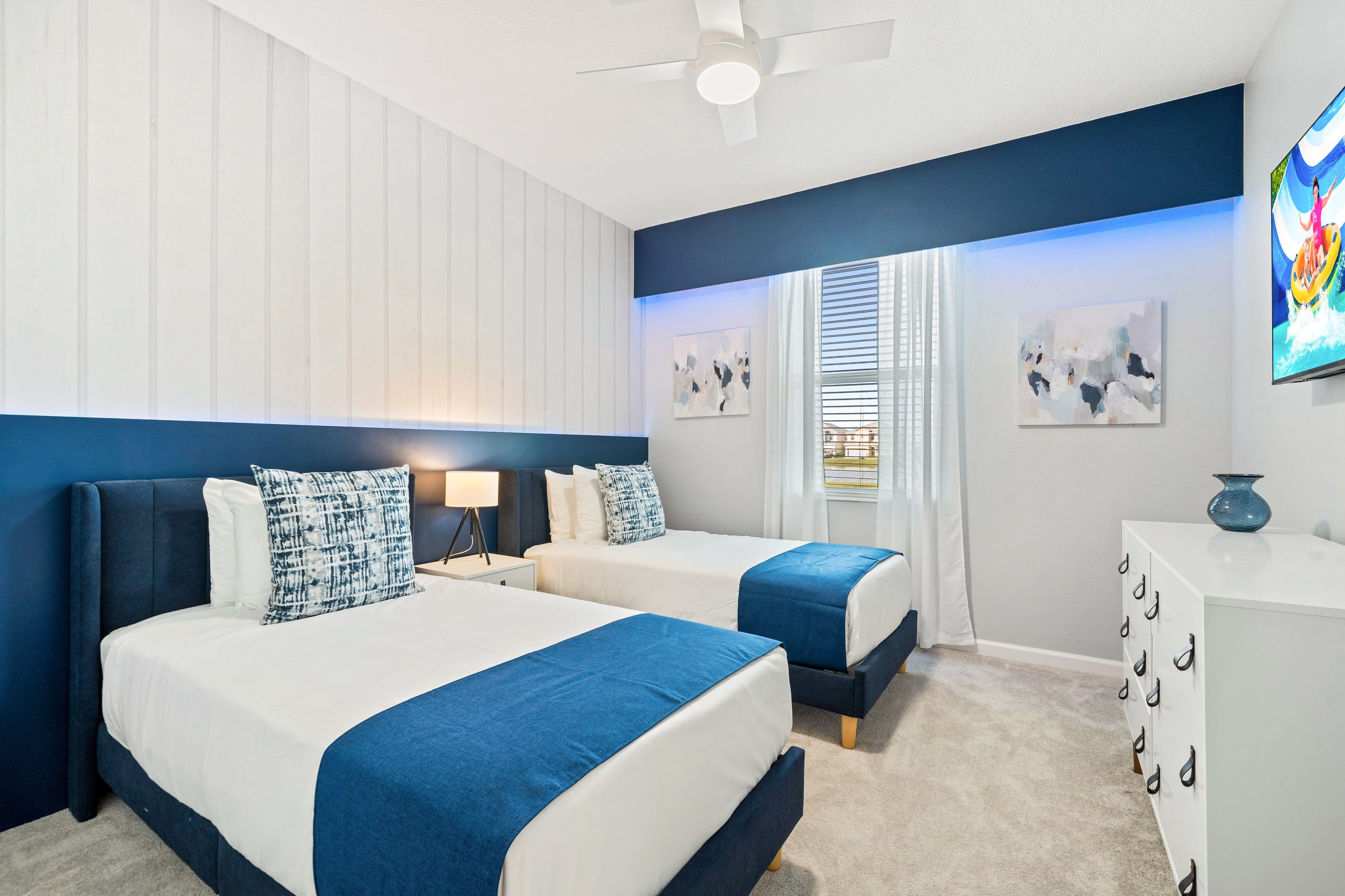Bright Bedroom Featuring Two Twin Beds And Stylish Blue Accents