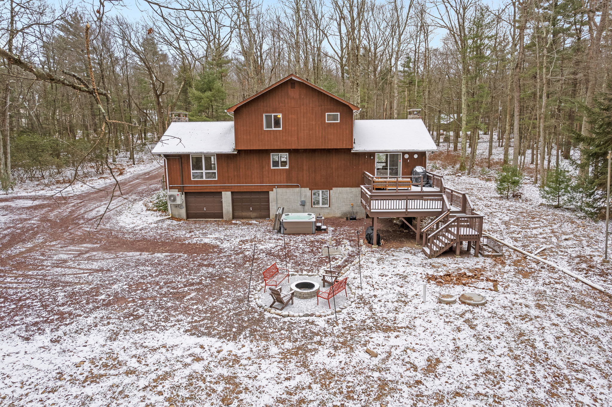This cozy cabin-style home offers a peaceful retreat, surrounded by a picturesque snowy landscape.