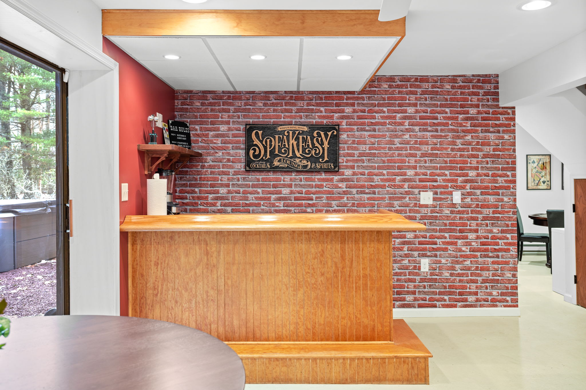 Step up to this stylish wooden bar with exposed brick walls and vintage signage, creating the perfect atmosphere for a relaxed evening.